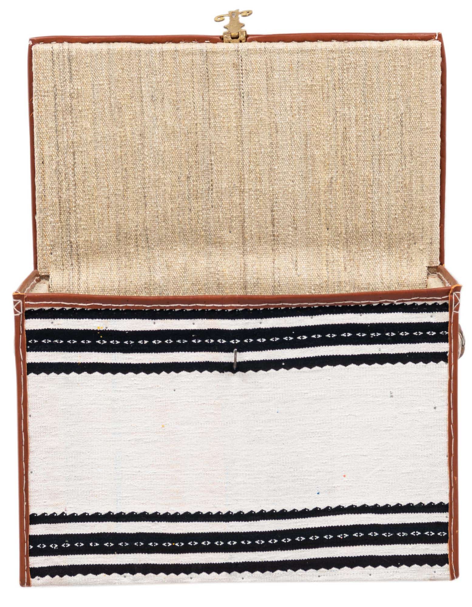 Open rectangular storage trunk featuring a white woven exterior with black striped patterns and brown leather trim.