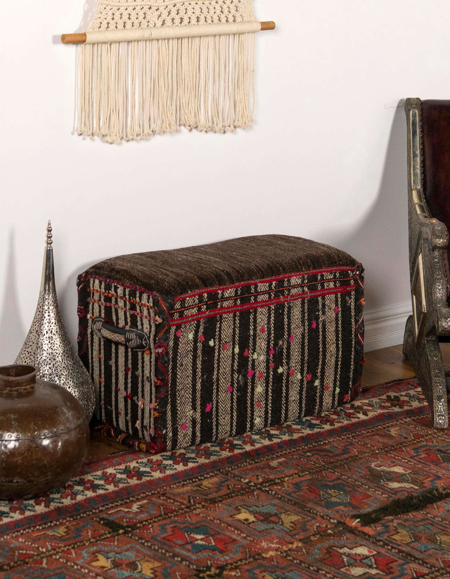 A 1x2 rectangular brown and tan traditional rug with intricate oriental patterns in a living room setting.