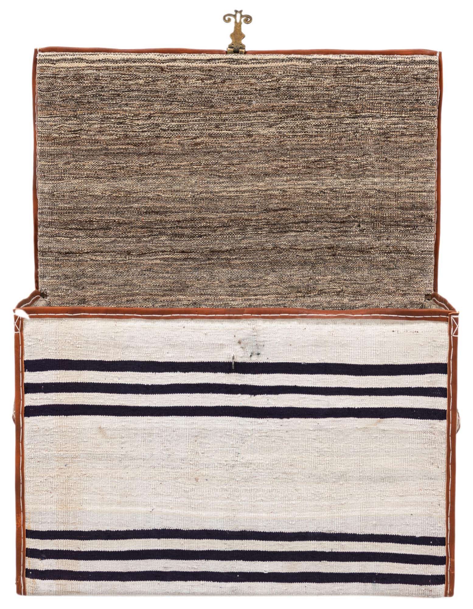 An open rectangular storage chest with a textured black and white striped rug pattern on the front and a brown woven texture on the lid, accented with leather trim and a brass latch.