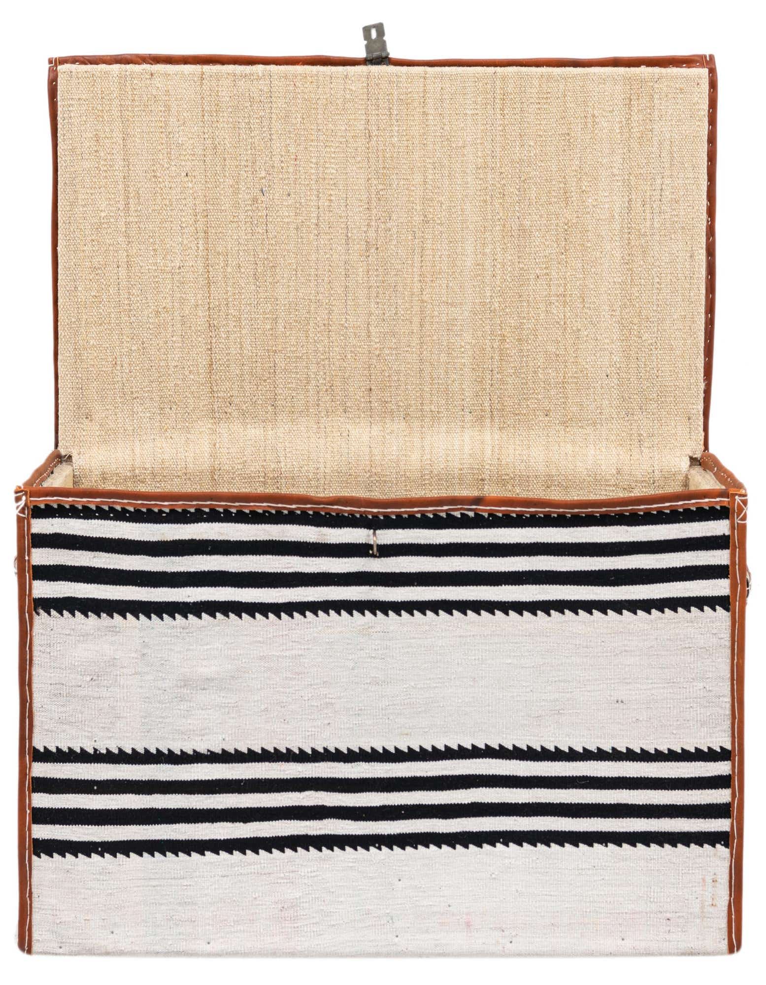 Open rectangular storage chest with a black and white striped textile exterior and light brown leather trim.