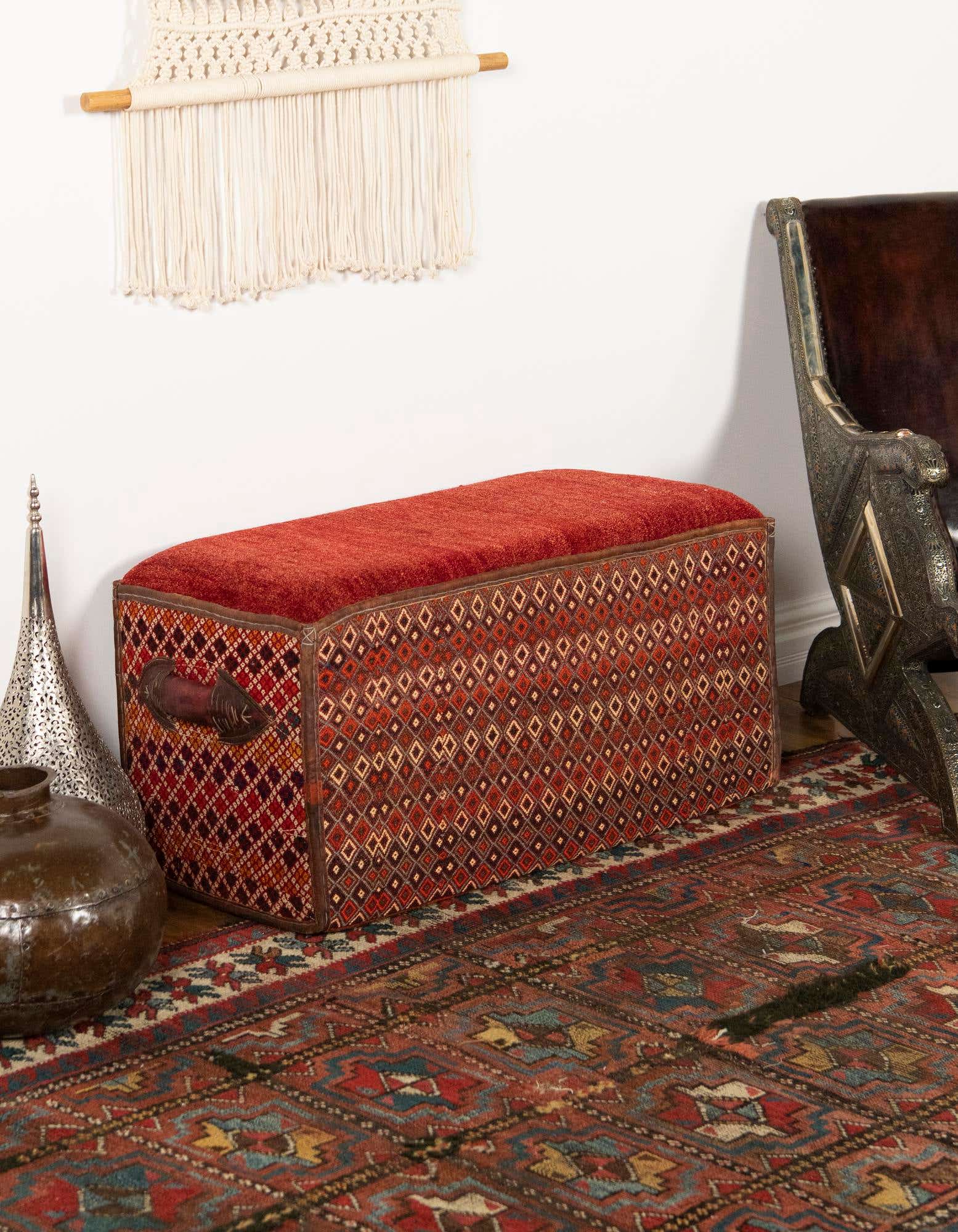 A 2x3 rectangular orange and red traditional oriental rug with a detailed pattern, laid on a wooden floor in an entryway.