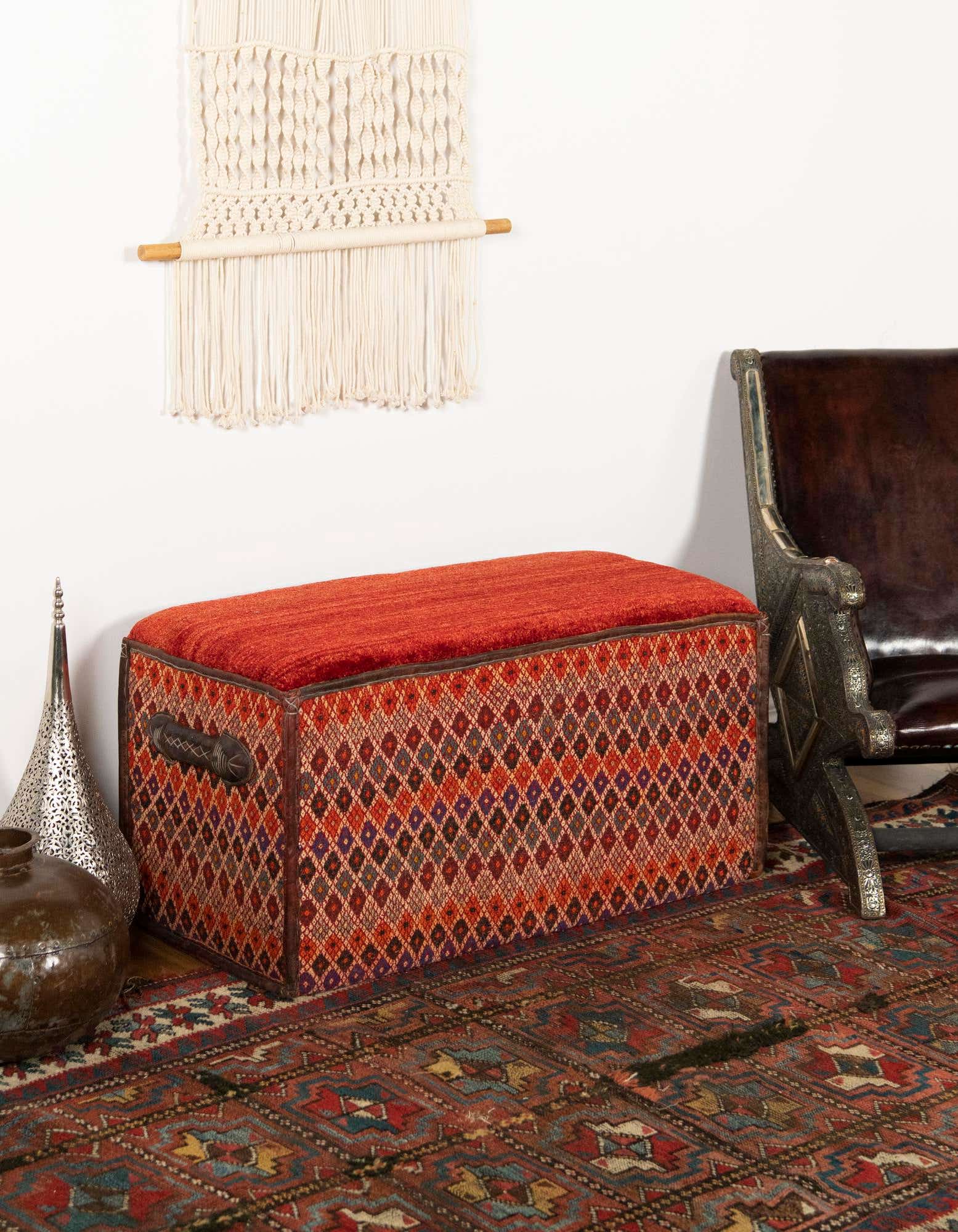 A 2x3 rectangular orange and red rug with a traditional pattern, styled in a living room setting.