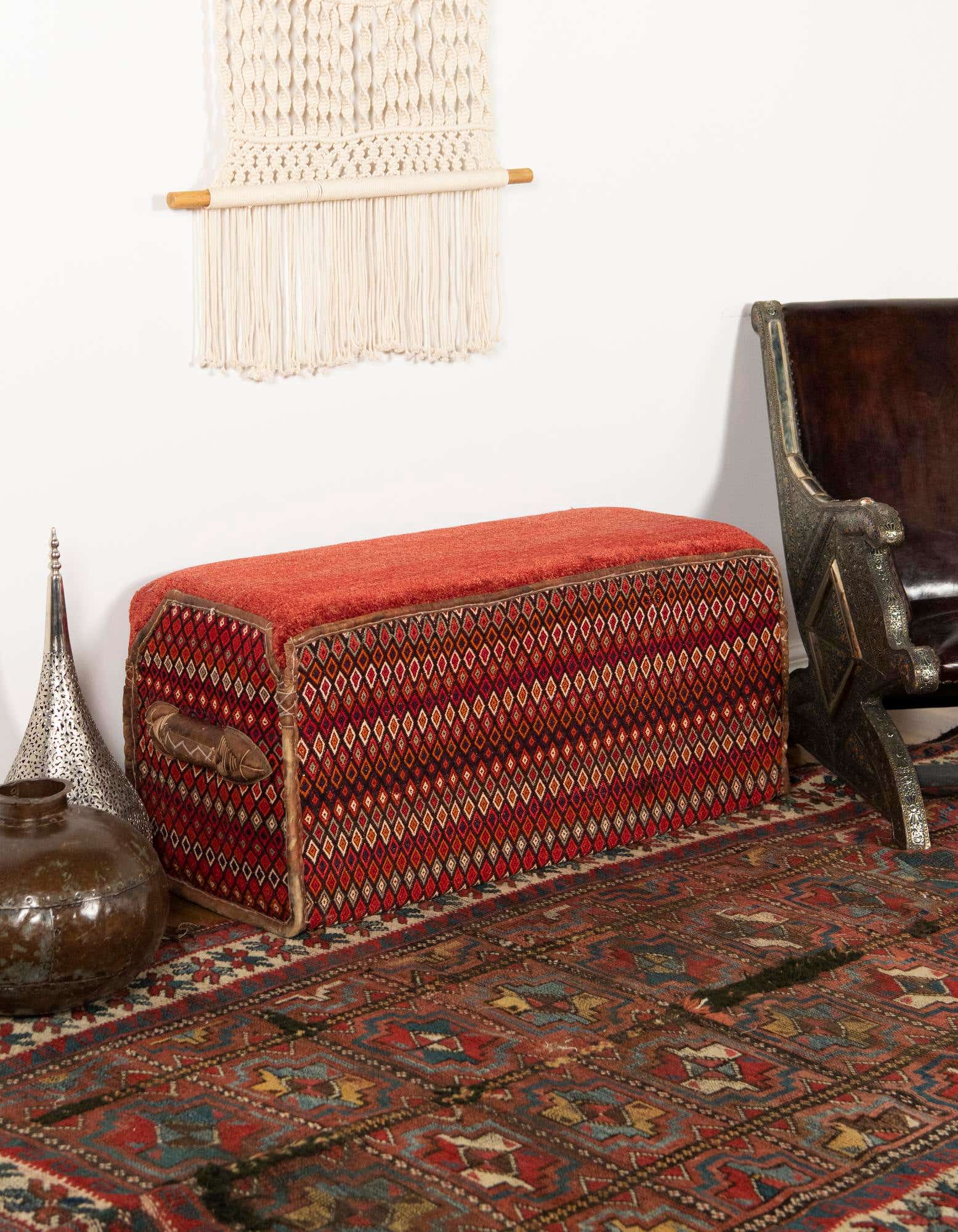 A 2x3 rectangular orange and red traditional rug with an oriental pattern on a dark red floor.