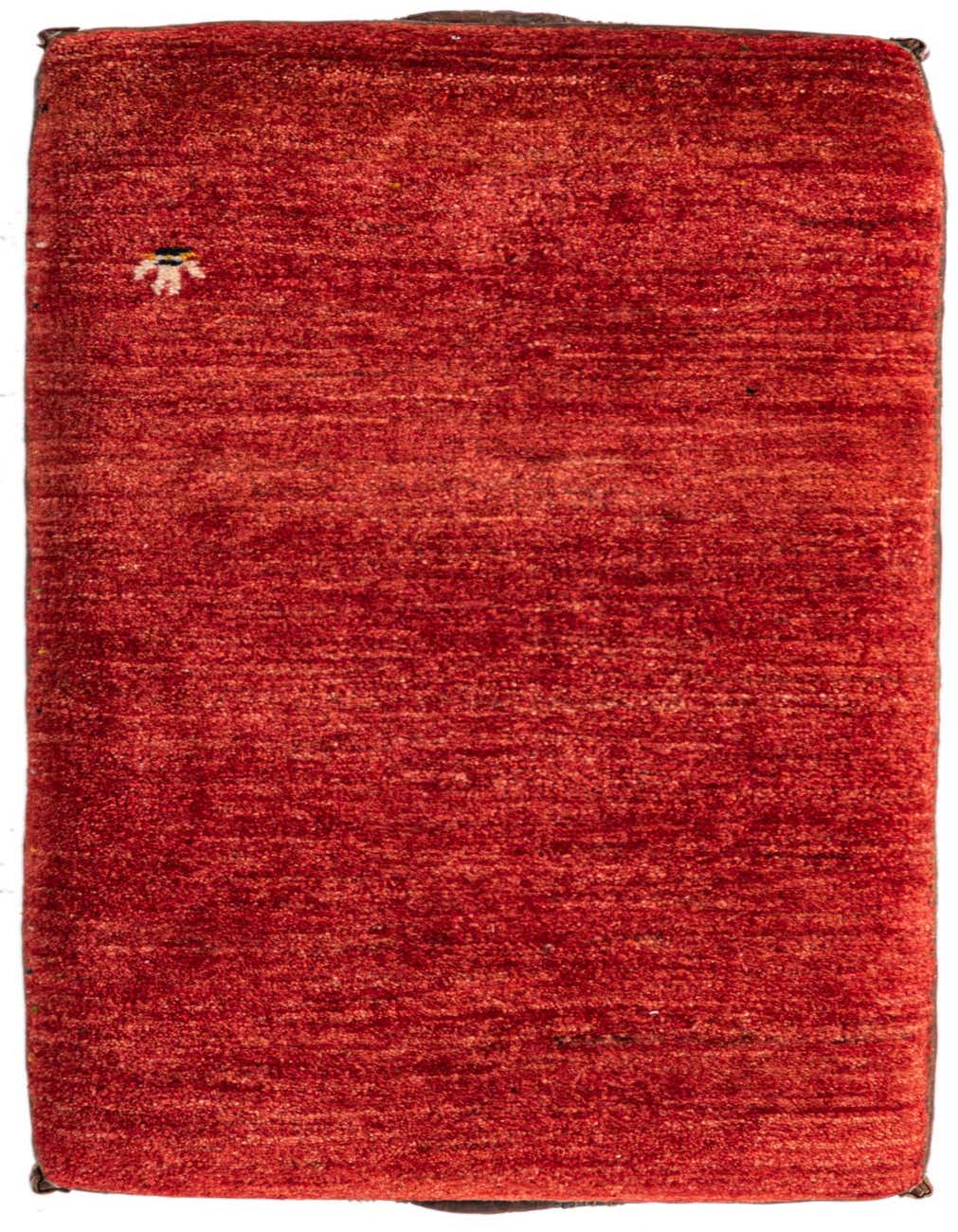 A 2x3 rectangular orange and red rug with a subtle geometric pattern and a small, colorful motif in the corner.