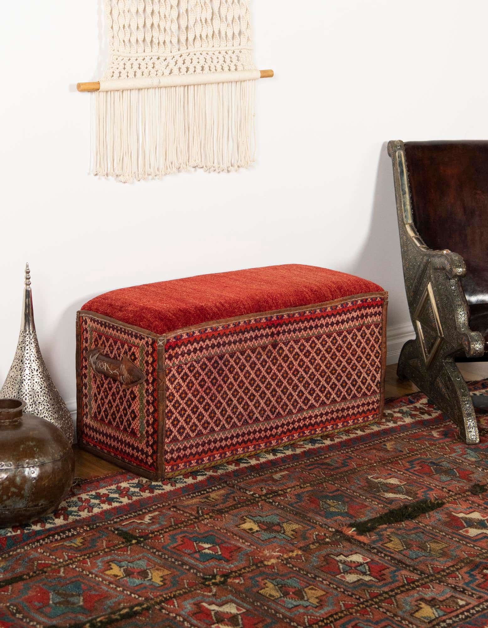 A rectangular 2x3 traditional orange and red rug with intricate patterns, laid on a wooden floor in a living room setting.