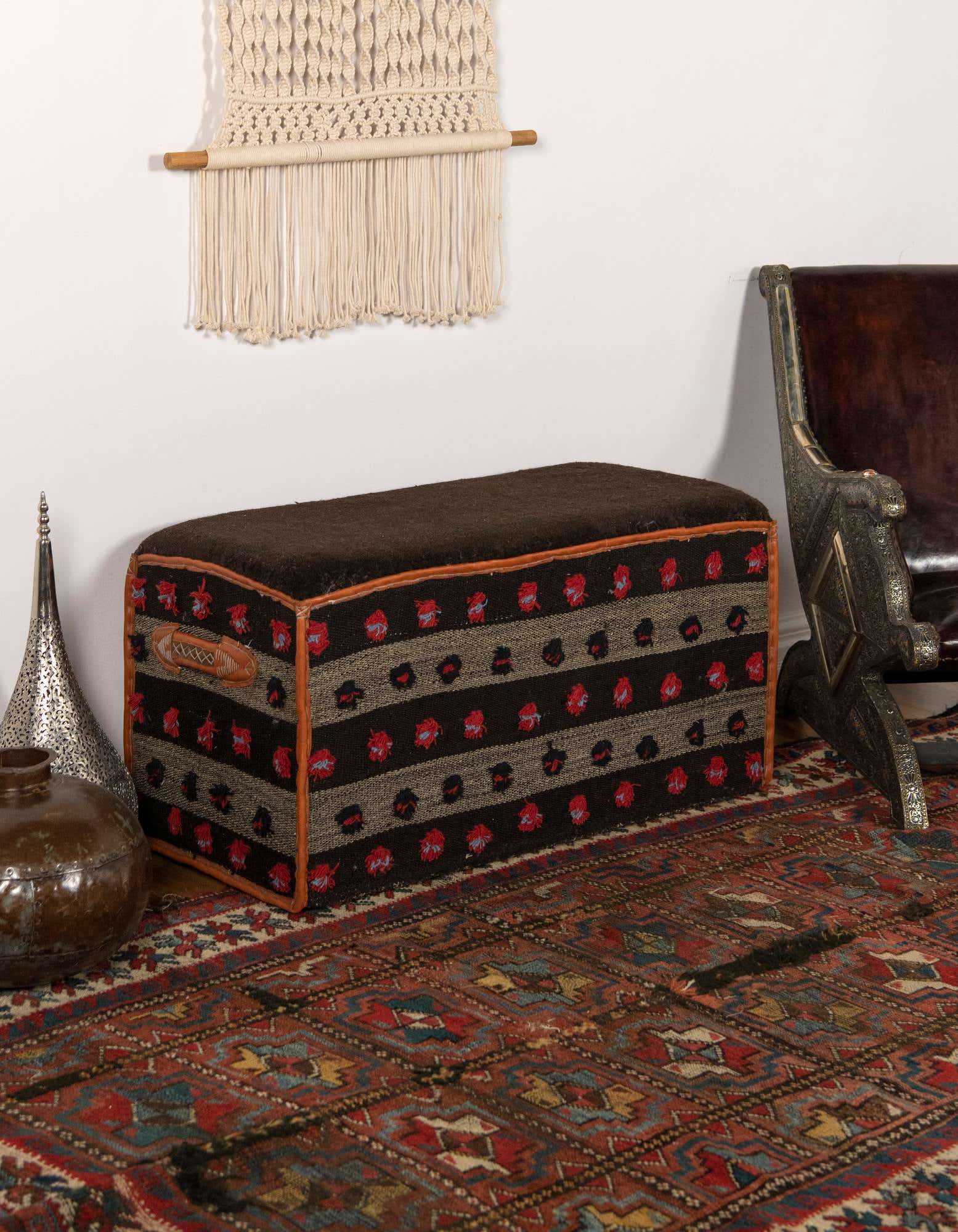 A 2x3 rectangular traditional brown and tan rug with an oriental stripe pattern, under a decorative ottoman.