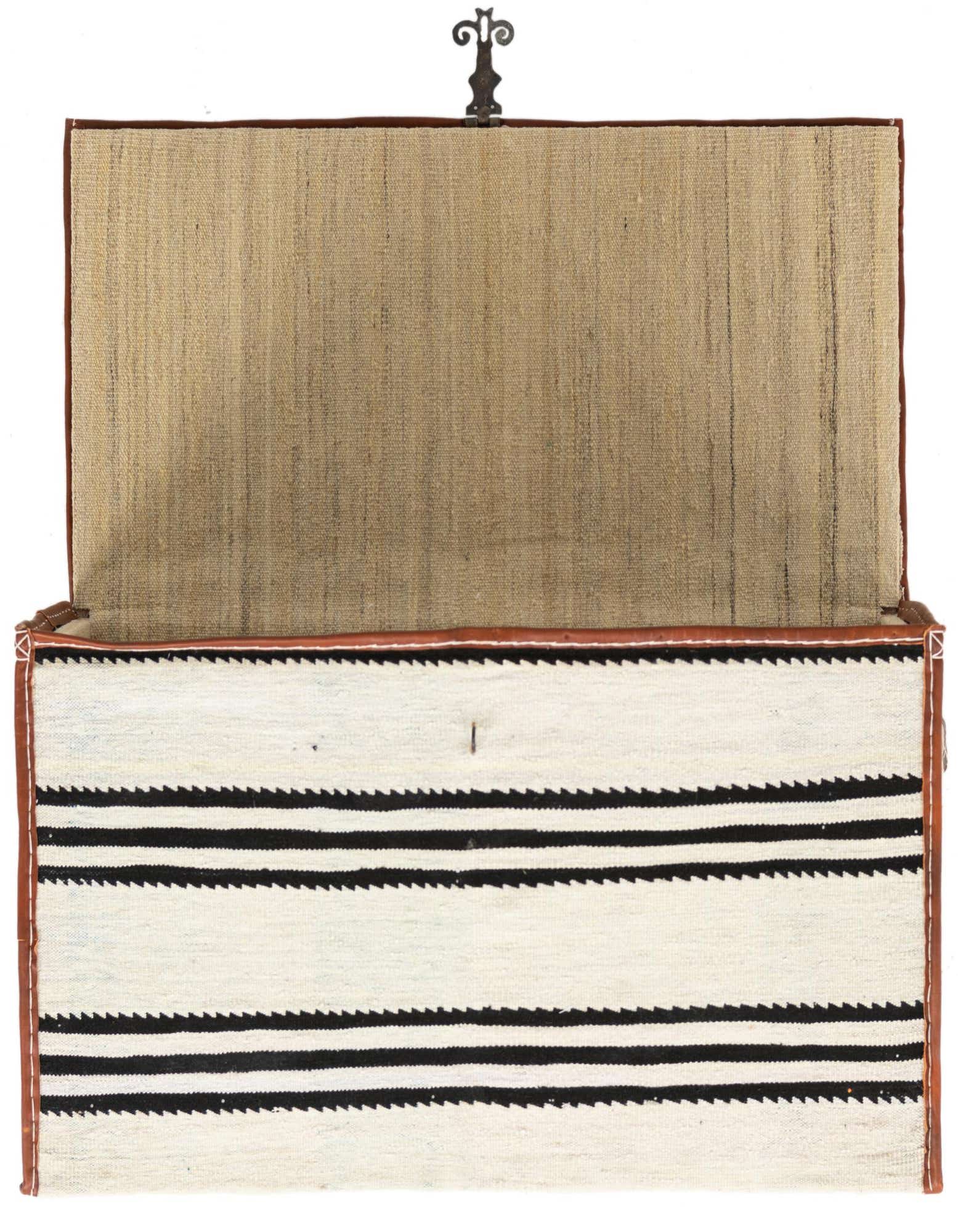 Open rectangular storage box with a white and black striped woven rug exterior and a natural fiber interior.