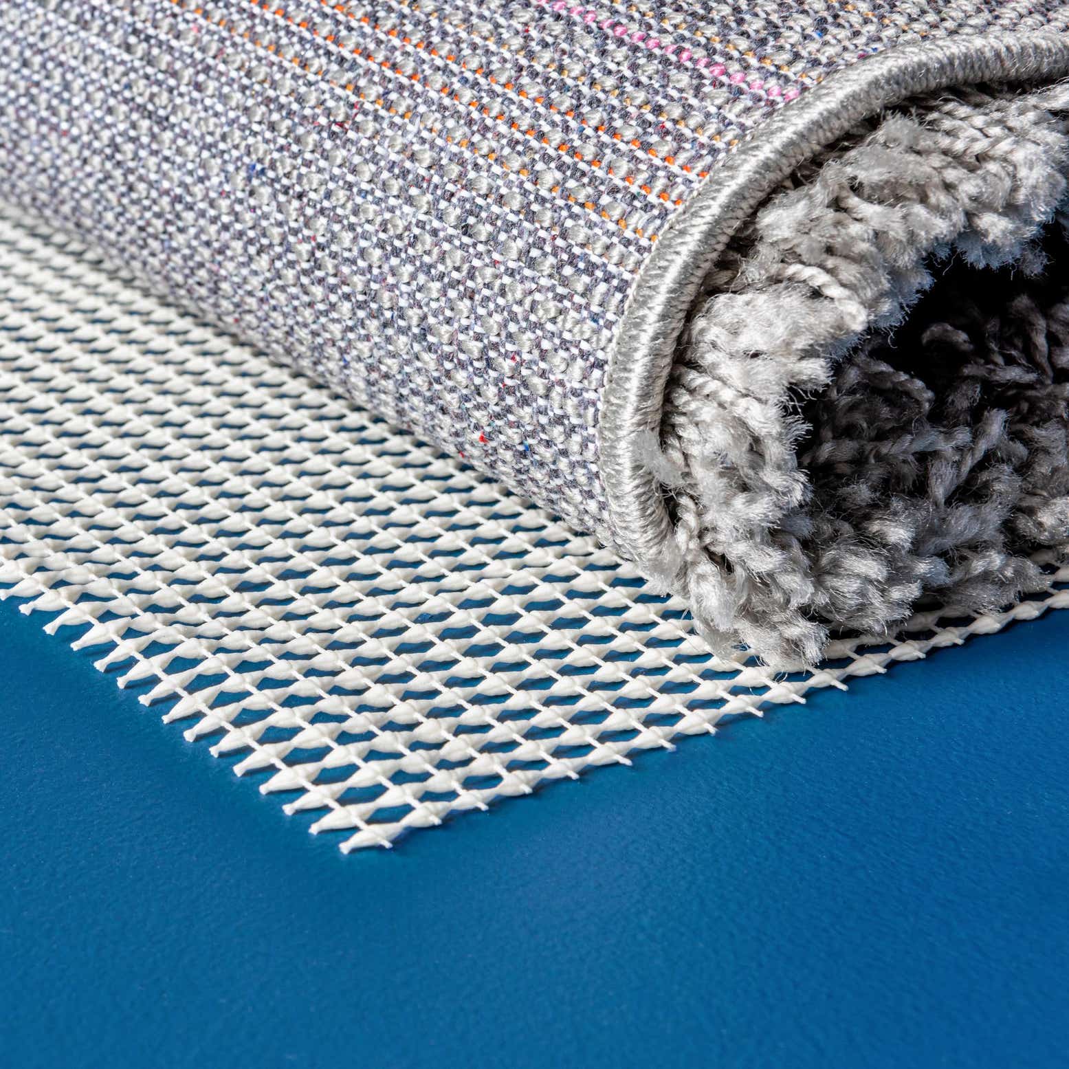 White rectangular rug pad with a repeating honeycomb pattern, designed to prevent rugs from slipping.