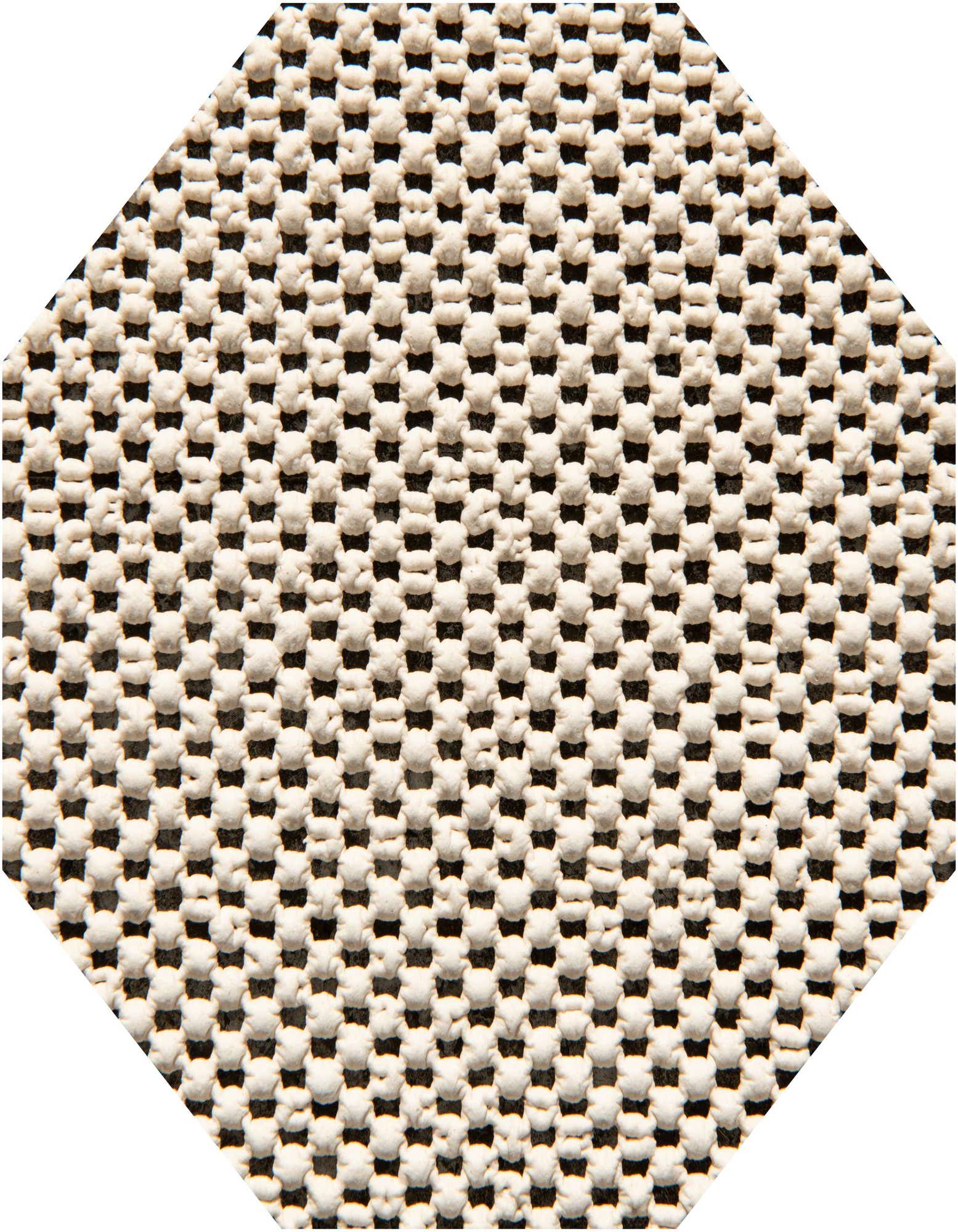 Close-up of a white textured rug pad with a grid pattern of small raised bumps, designed for non-slip use.