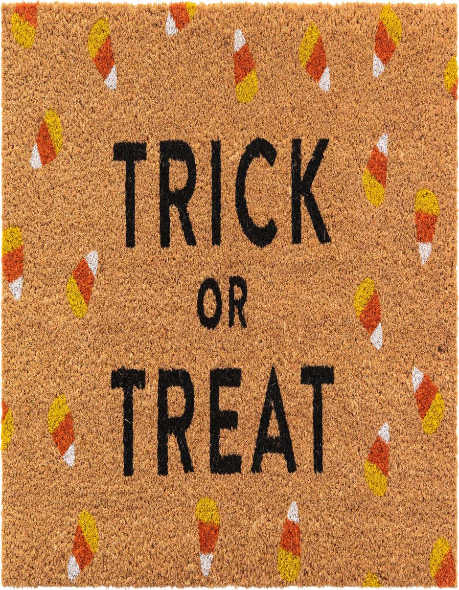 A rectangular brown coir doormat with "TRICK OR TREAT" in black text, surrounded by scattered candy corn.