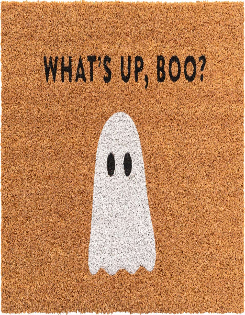 A rectangular coir doormat with a tan background features a white ghost and the text "WHAT'S UP, BOO?" in black.