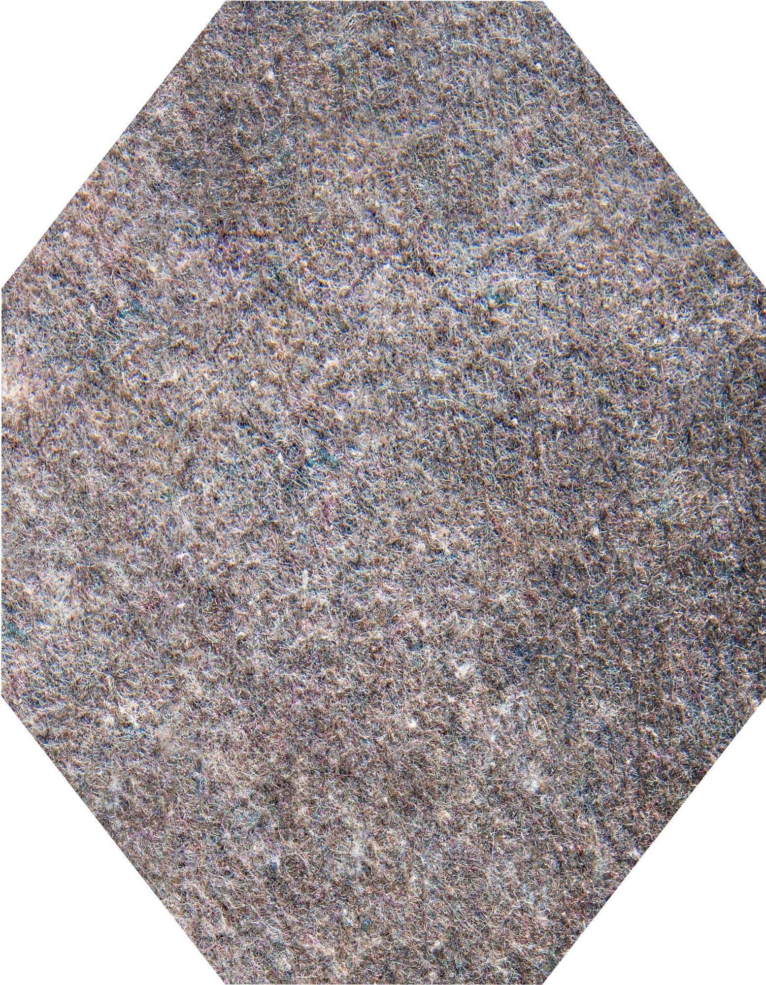 Close-up of a gray octagon rug pad with a textured, felt-like surface, designed for indoor use.