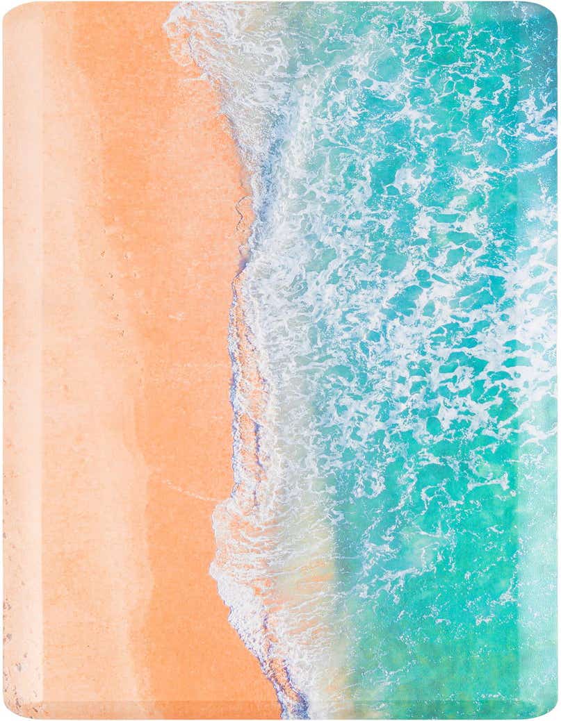 Overhead view of a rectangular blue and khaki rug, depicting a sandy beach meeting foamy ocean waves.