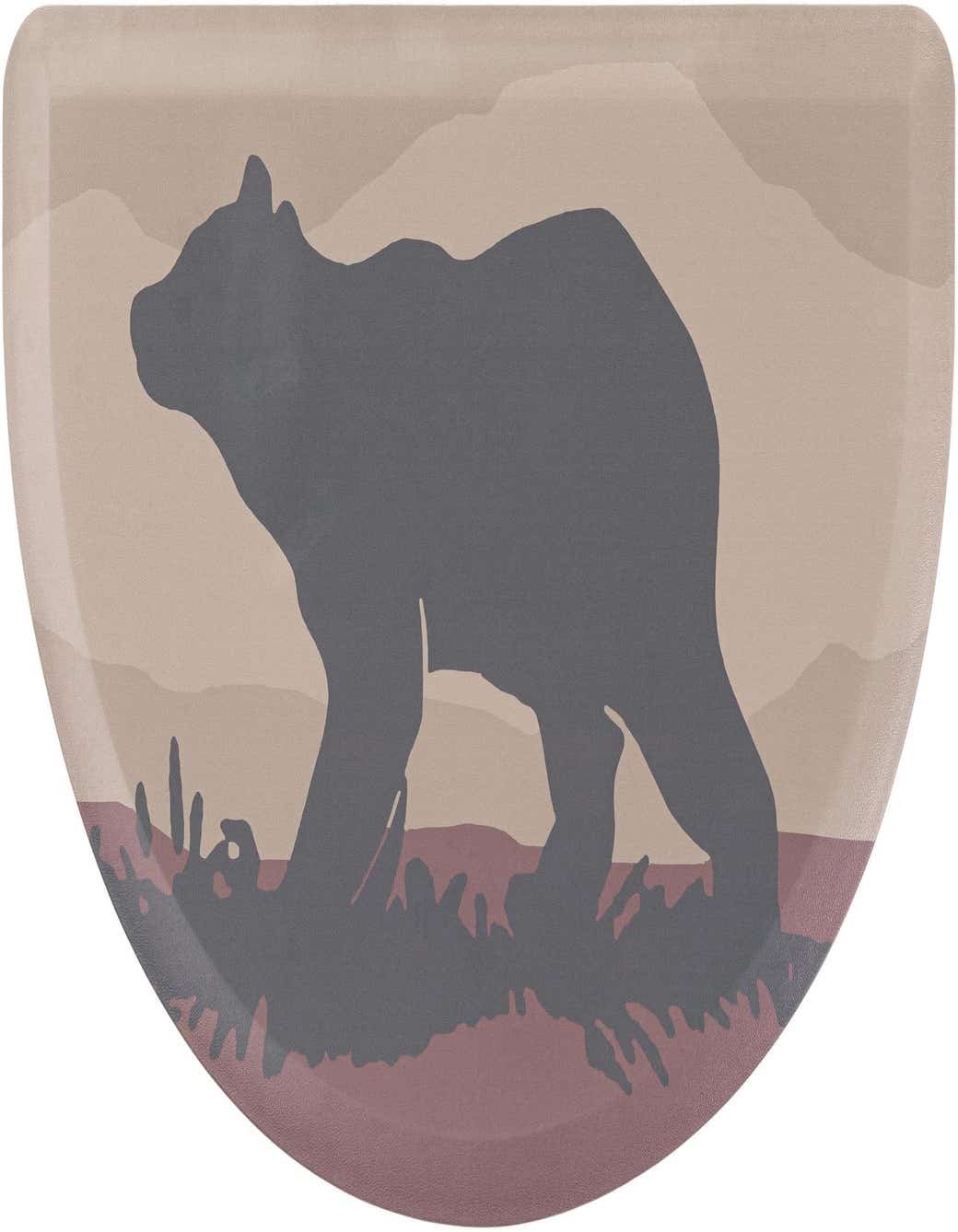 A hearth-shaped mat featuring a dark gray bear silhouette against a multi-colored, muted landscape background with beige and reddish-brown tones.