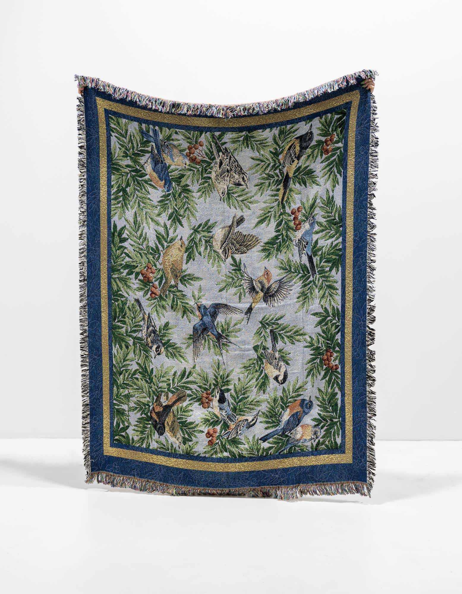 A 4x6 multi-colored rectangular throw blanket featuring a modern bird and botanical pattern with a blue border and fringe.