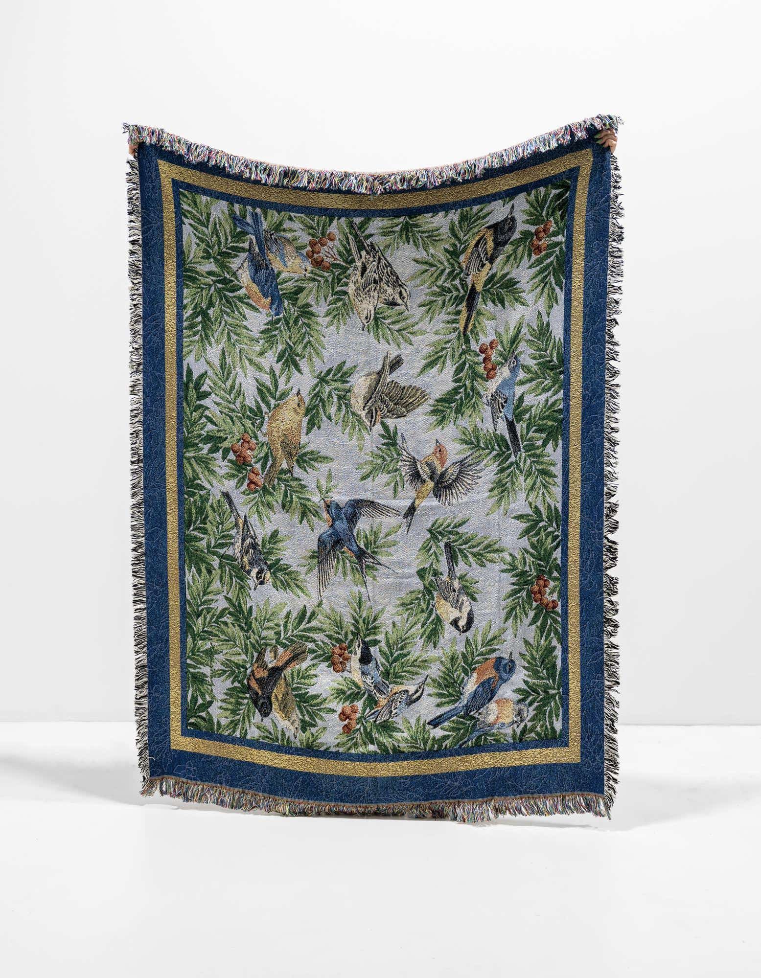 A 4x6 multi-colored rectangular throw blanket featuring a modern bird and botanical pattern with a blue border and fringe.