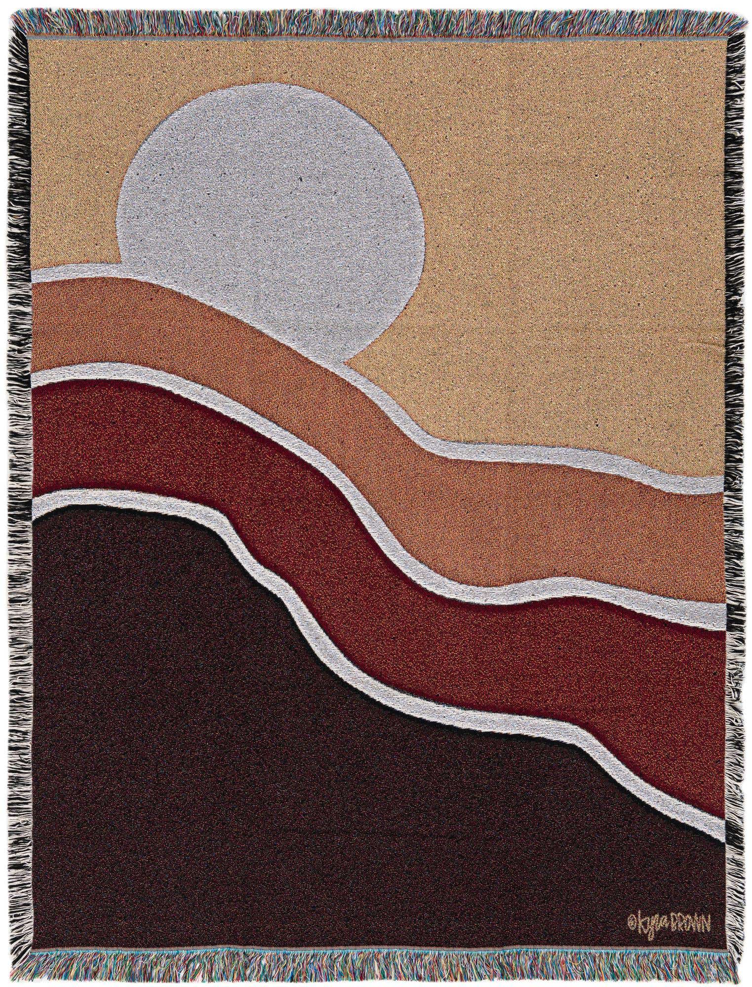 A 4x6 rectangular throw blanket featuring a modern abstract design with a large light gray circle resembling a sun over wavy bands of tan, orange, red, and dark brown, all outlined in white.