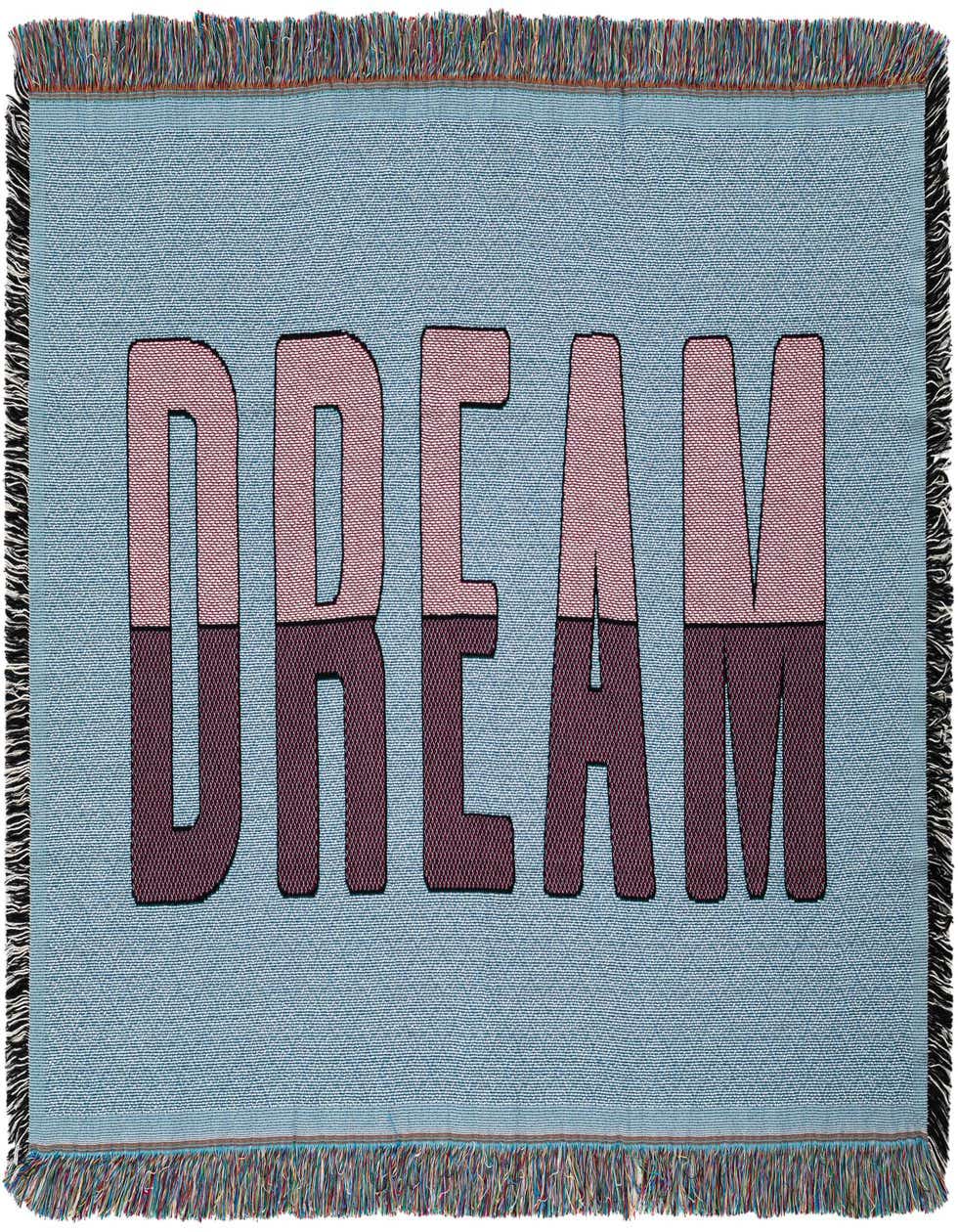 A 4x6 rectangular blue cotton throw blanket with the word "DREAM" in pink and purple split lettering, featuring fringed edges.
