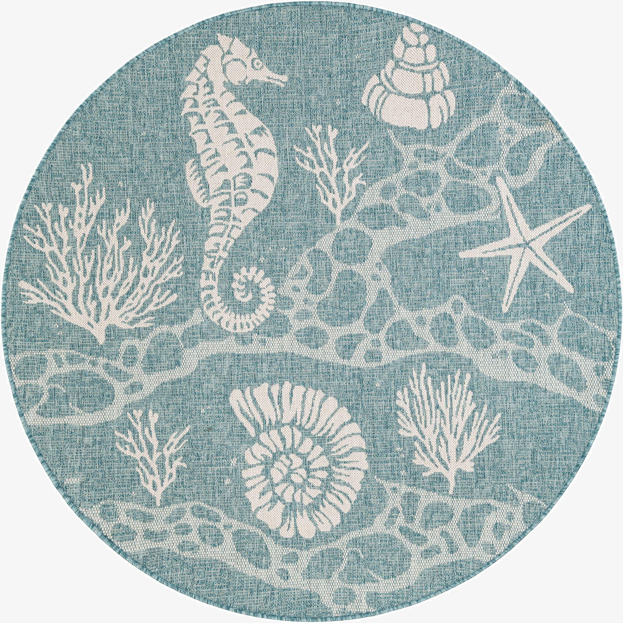 A round blue indoor/outdoor rug with a white coastal pattern featuring a seahorse, starfish, seashells, and coral.