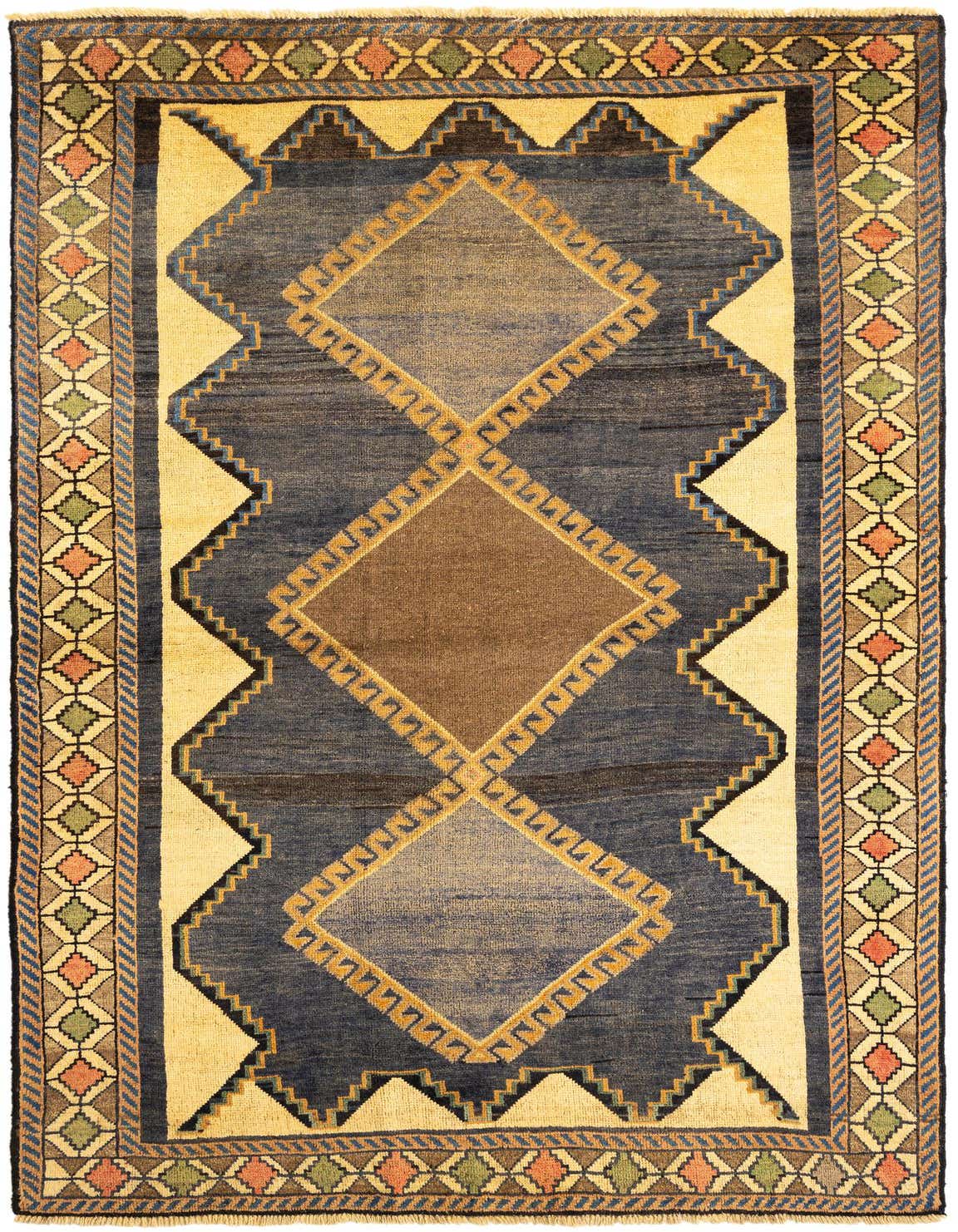 A 5x8 rectangular Gabbeh wool rug featuring a central brown diamond pattern on a blue field, with ivory and multi-colored geometric borders.