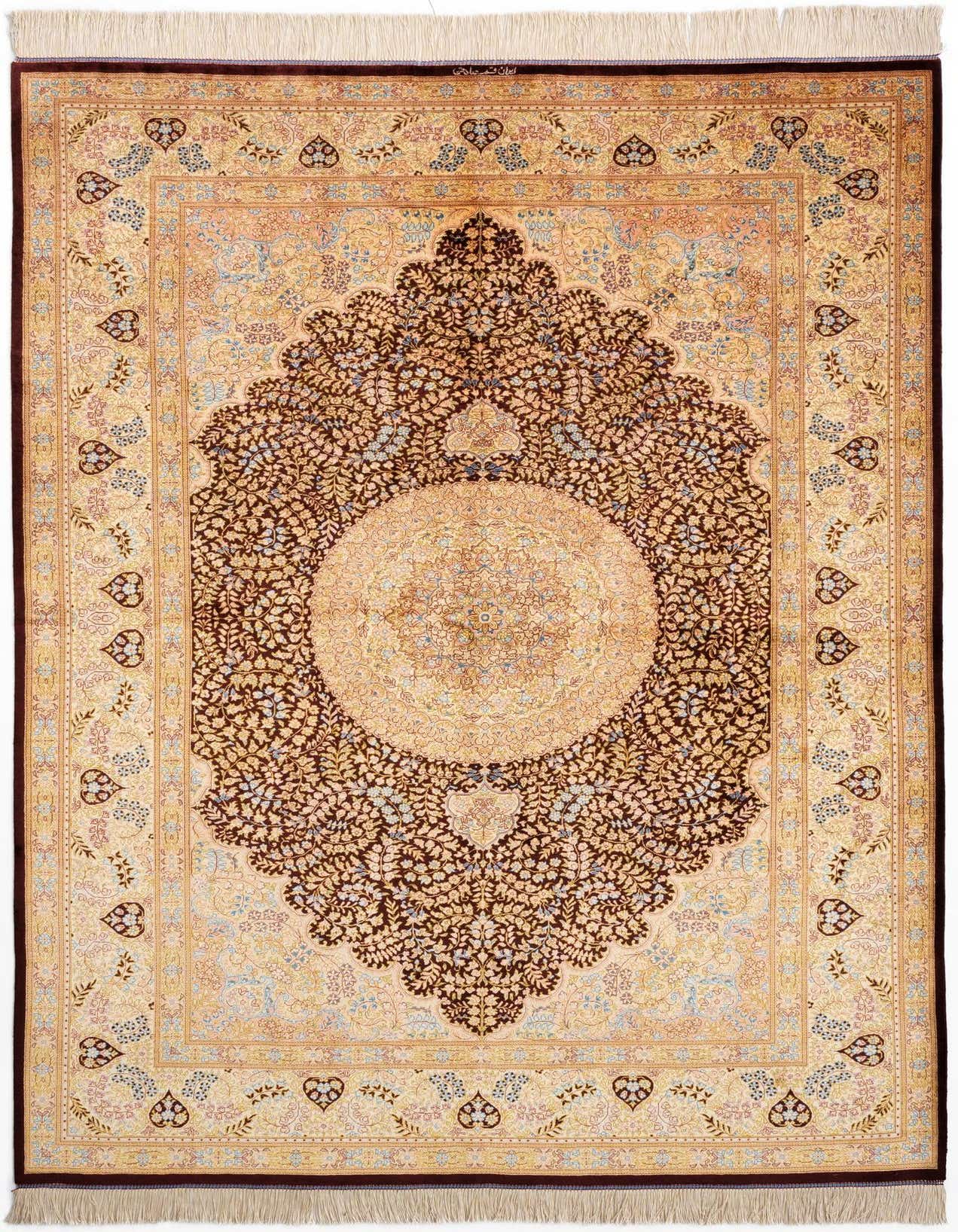 A luxurious 5x8 rectangular Ghom Silk Persian rug featuring a detailed ivory medallion on a rich brown floral field, framed by a tan border.