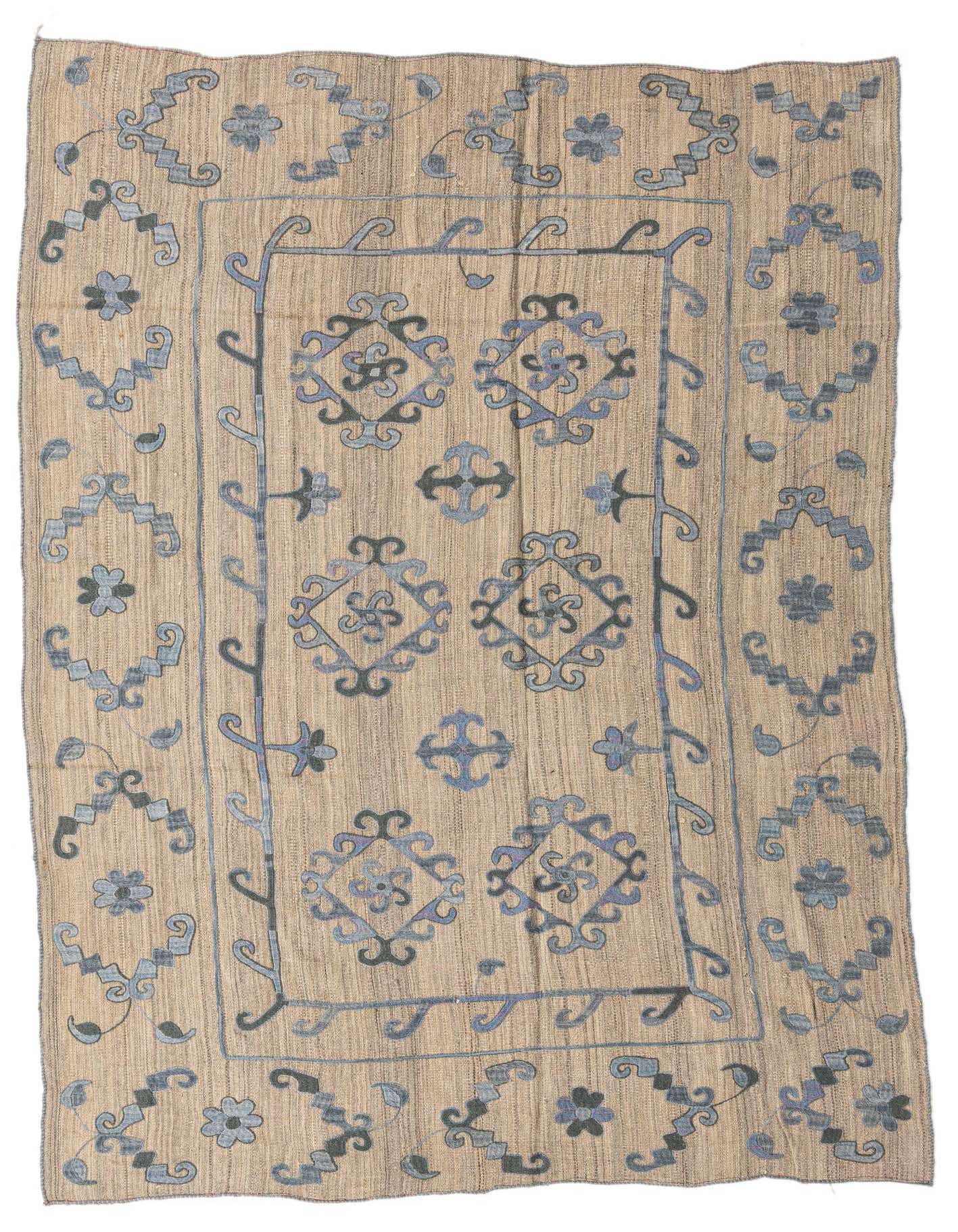 A 6x9 rectangular Kilim Modern rug with a flatweave, featuring a tan background and blue tribal patterns.