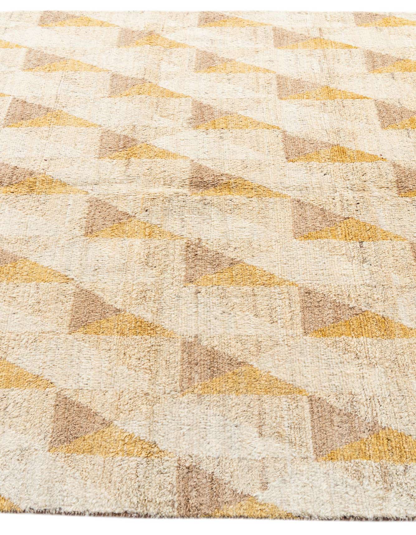 A 6x9 rectangular Moroccan shag rug with a tribal geometric pattern in cream, tan, and gold, suitable for a living room.