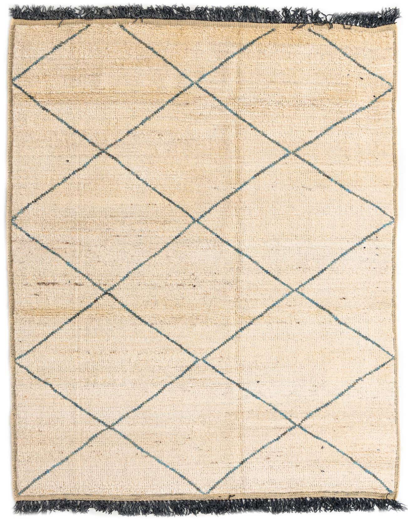A 6x9 rectangular Moroccan shag rug with a cream and tan base, featuring a tribal diamond pattern in blue, with dark fringed ends.