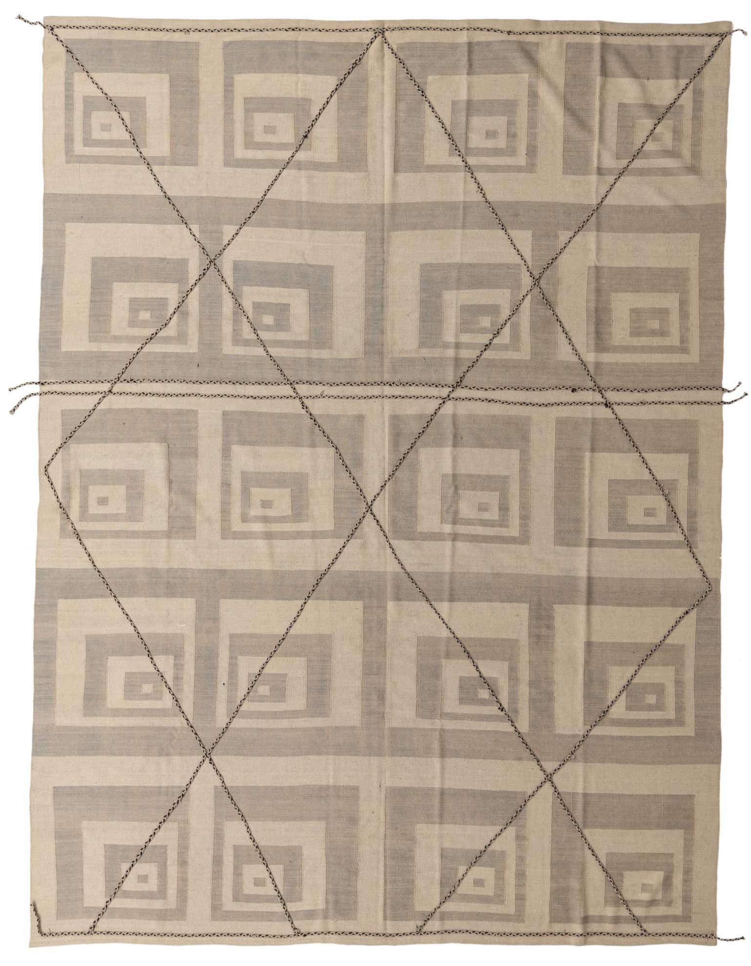 A 10x13 rectangular Moroccan shag rug with a tribal geometric pattern in brown and cream, handmade from wool.