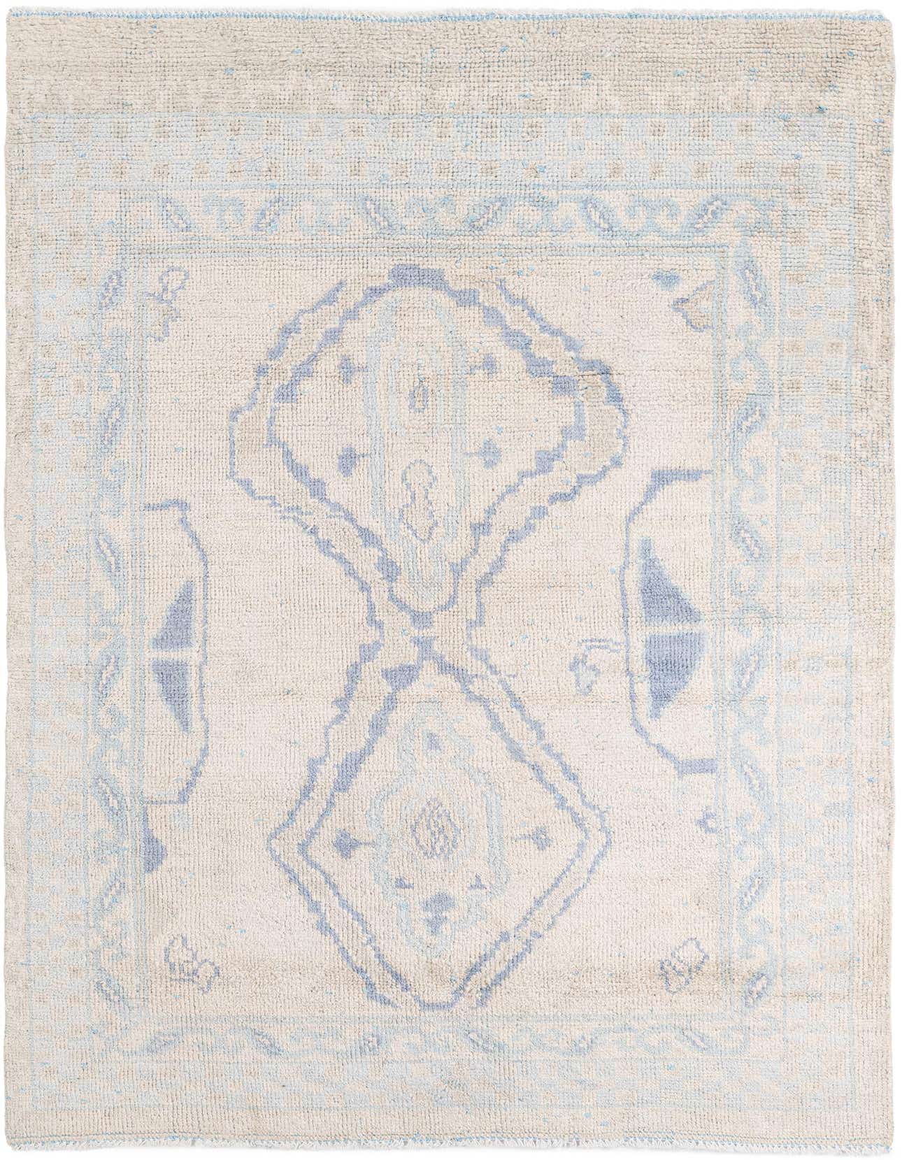 A 6x9 rectangular Moroccan shag rug in cream and light blue, featuring a tribal medallion pattern.