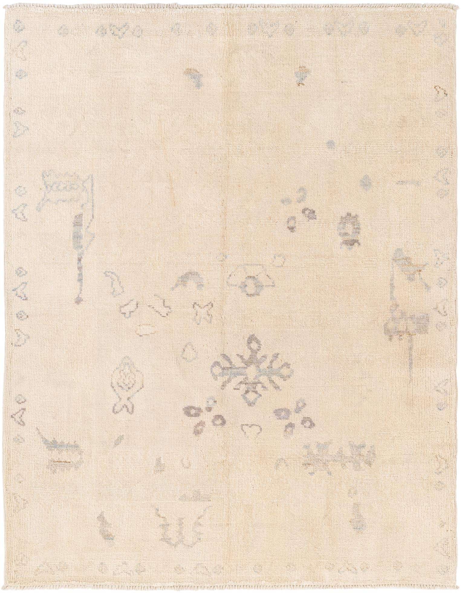 A 5x8 rectangular ivory wool shag rug with subtle brown tribal patterns, perfect for a modern living room.