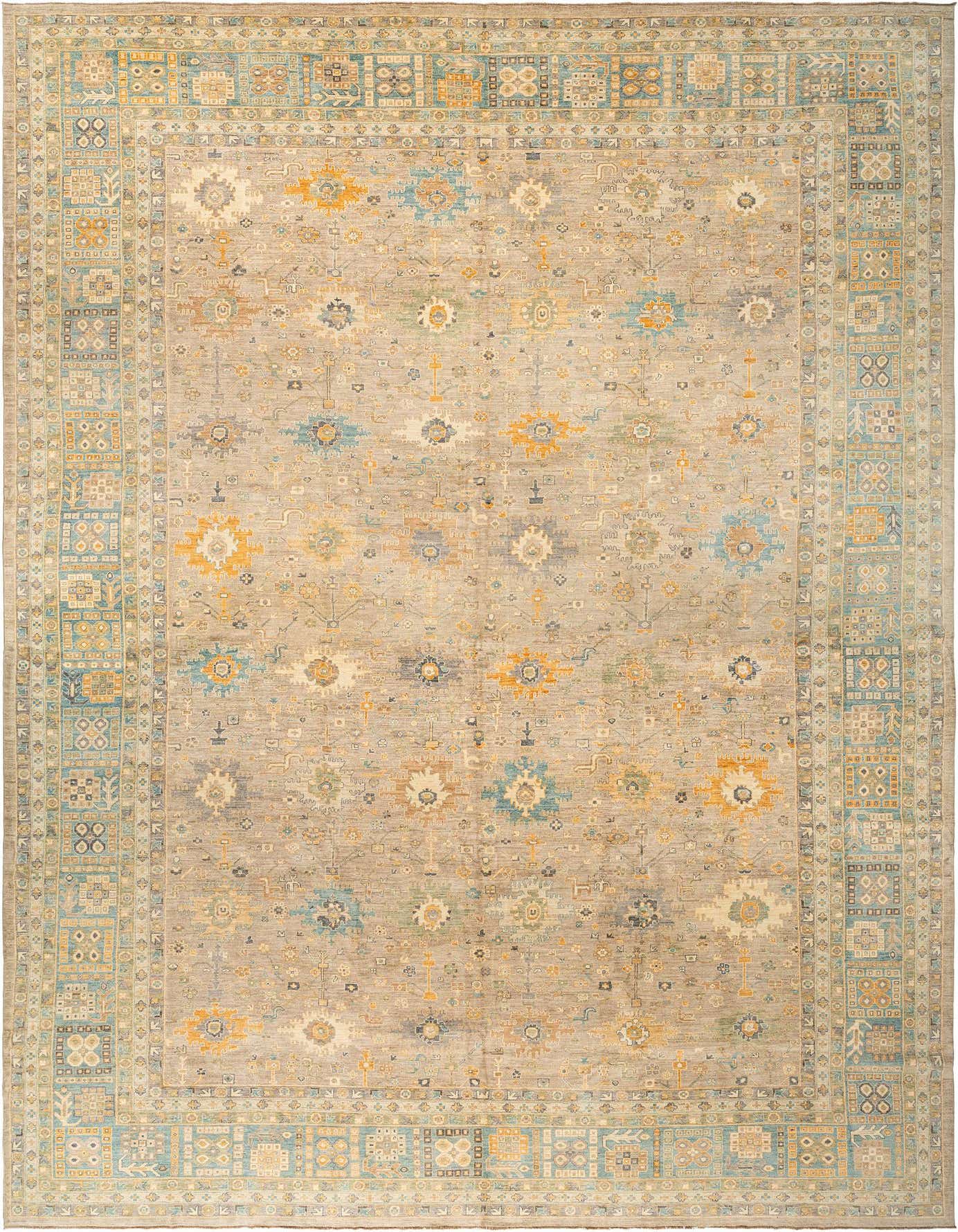 A large rectangular Oushak rug with a tan and brown field, featuring scattered ivory, blue, and orange floral motifs, and a detailed border.