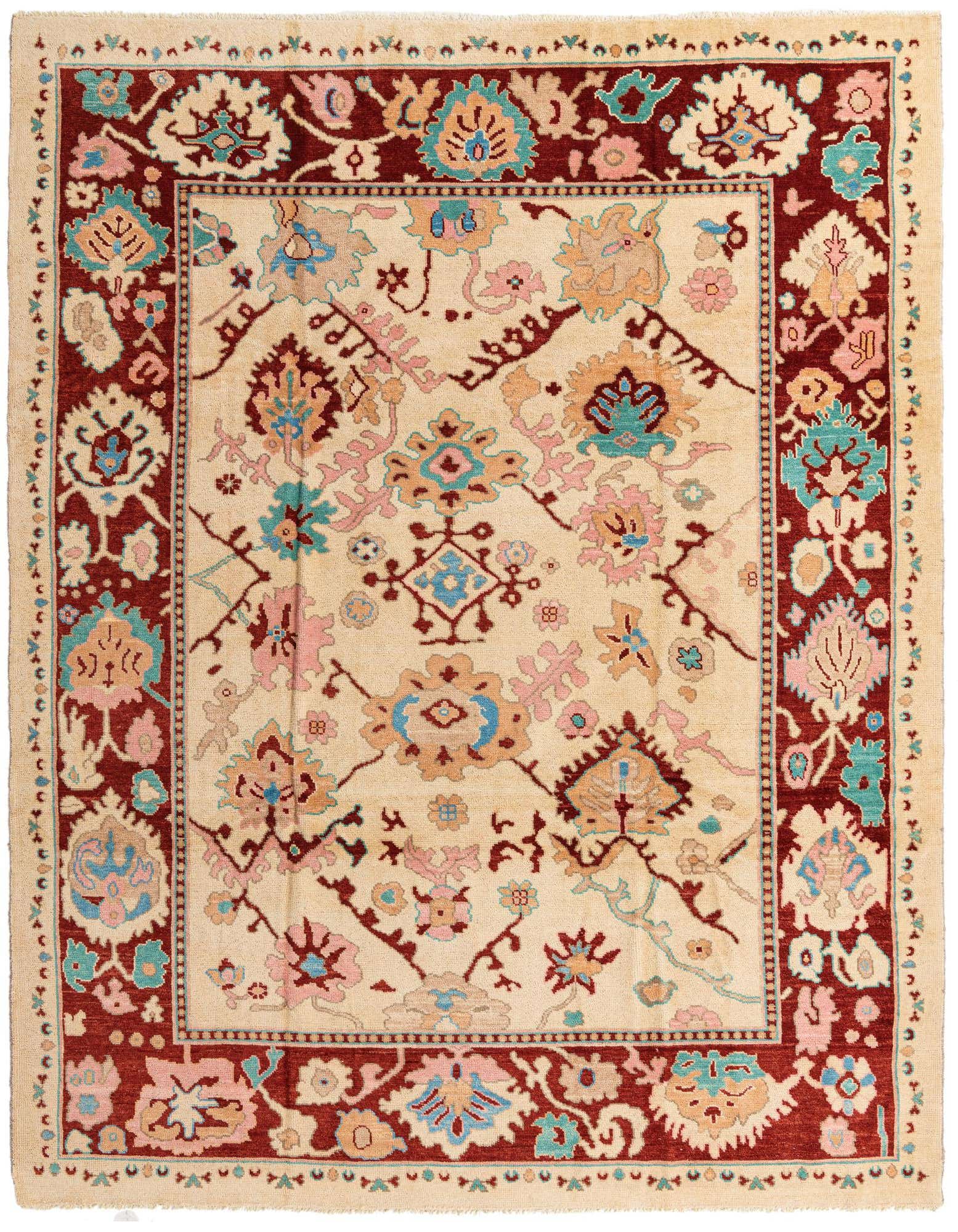 A 9x12 rectangular Oushak rug with a cream field, brown border, and abstract floral motifs in pink, blue, and tan.