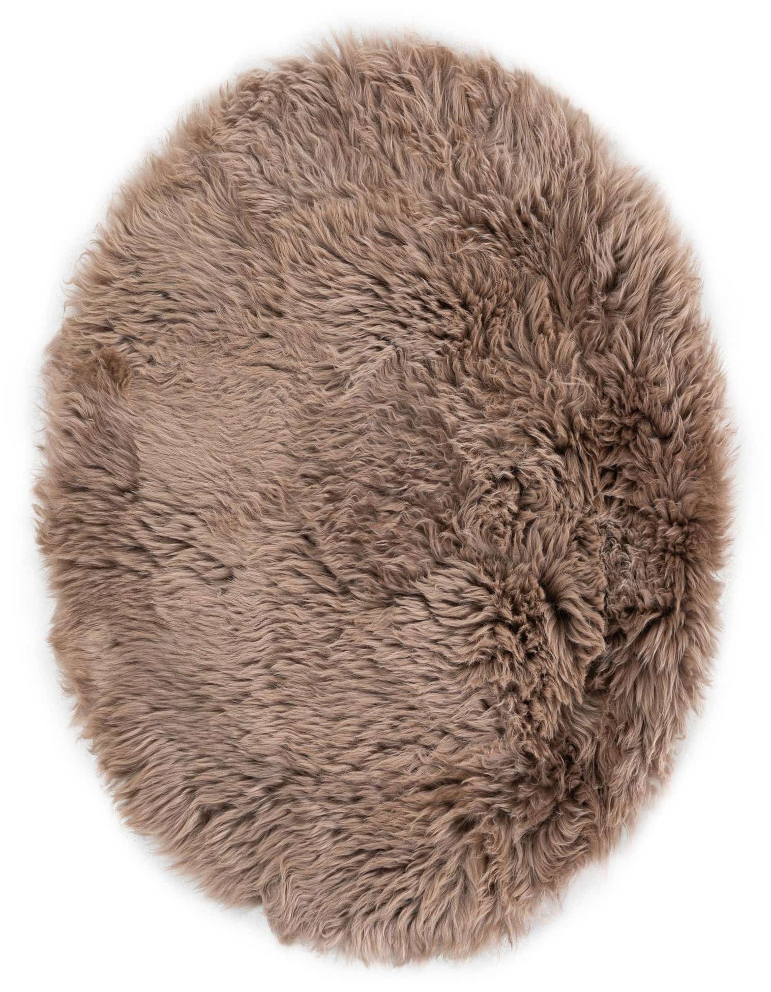 A soft, round 2' x 2' brown lambskin rug with a medium, shaggy pile, perfect for adding warmth.
