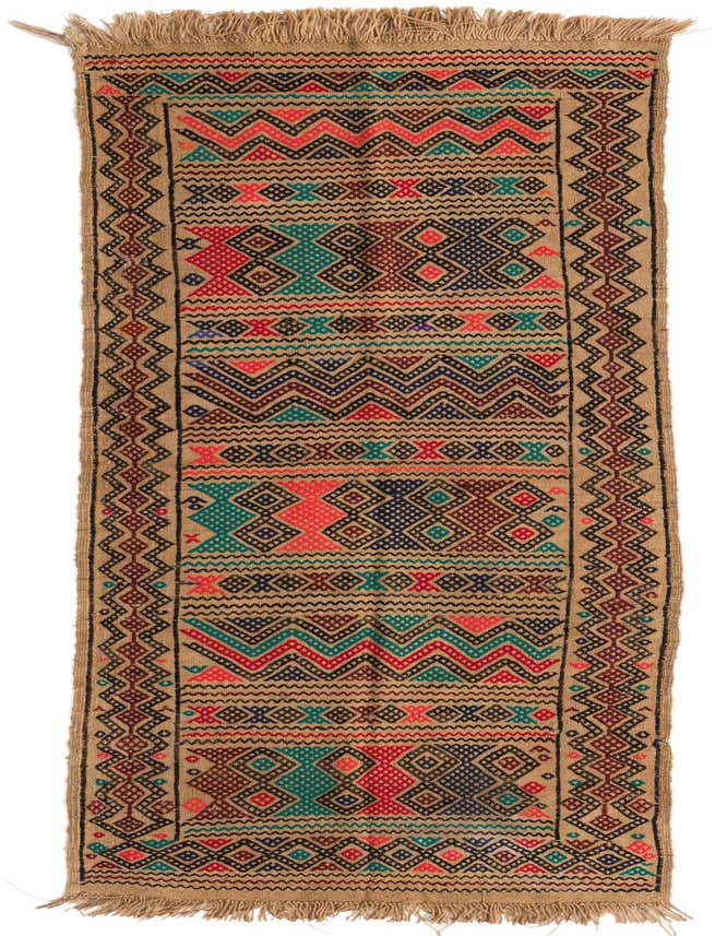 A handmade 8 ft Kilim Fars runner rug with a flatweave, featuring a tan background with vibrant tribal geometric patterns in red, teal, navy, and black.