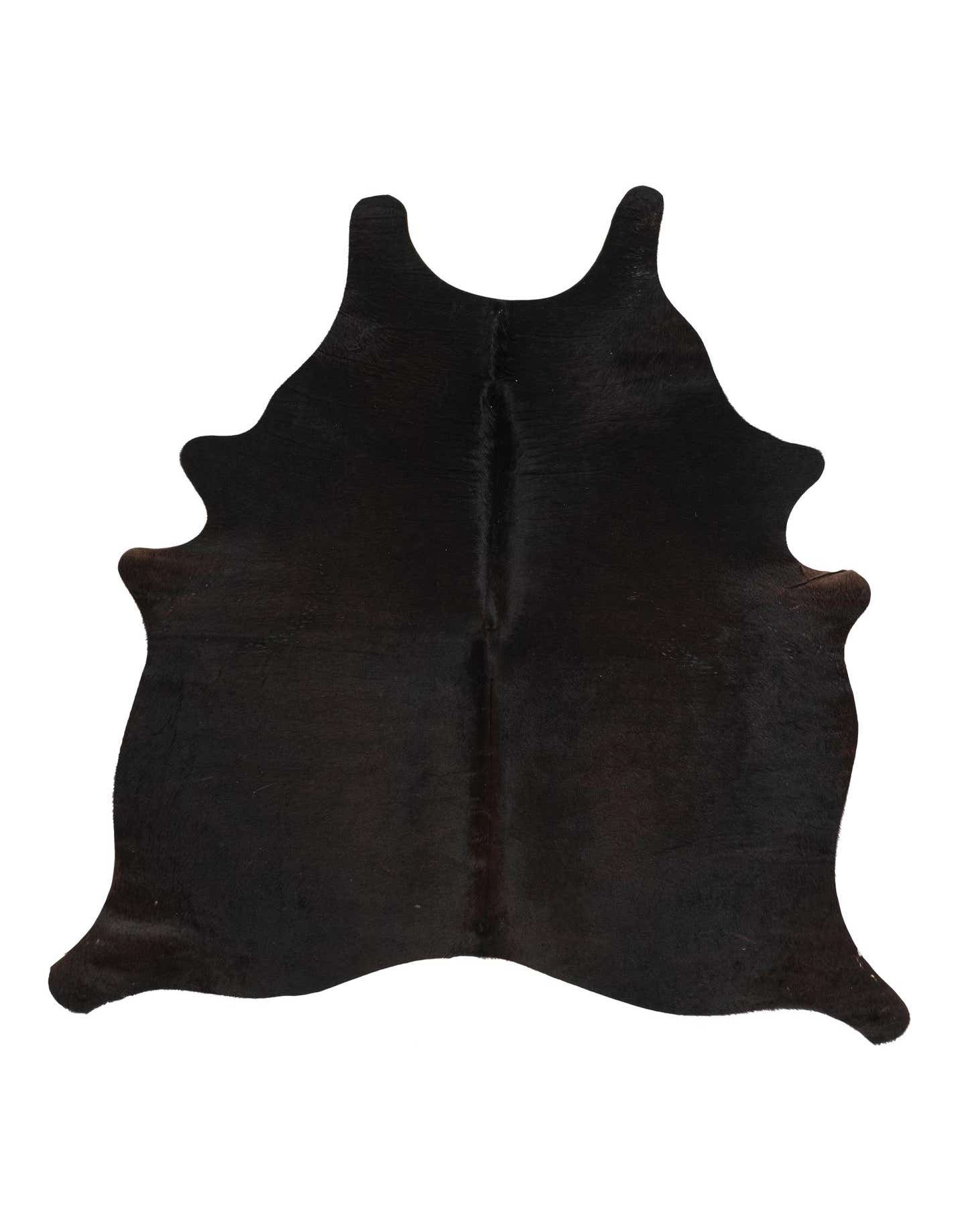A 4' 9 x 5' 0 freeform black cowhide rug with a natural, irregular shape and short, textured pile.