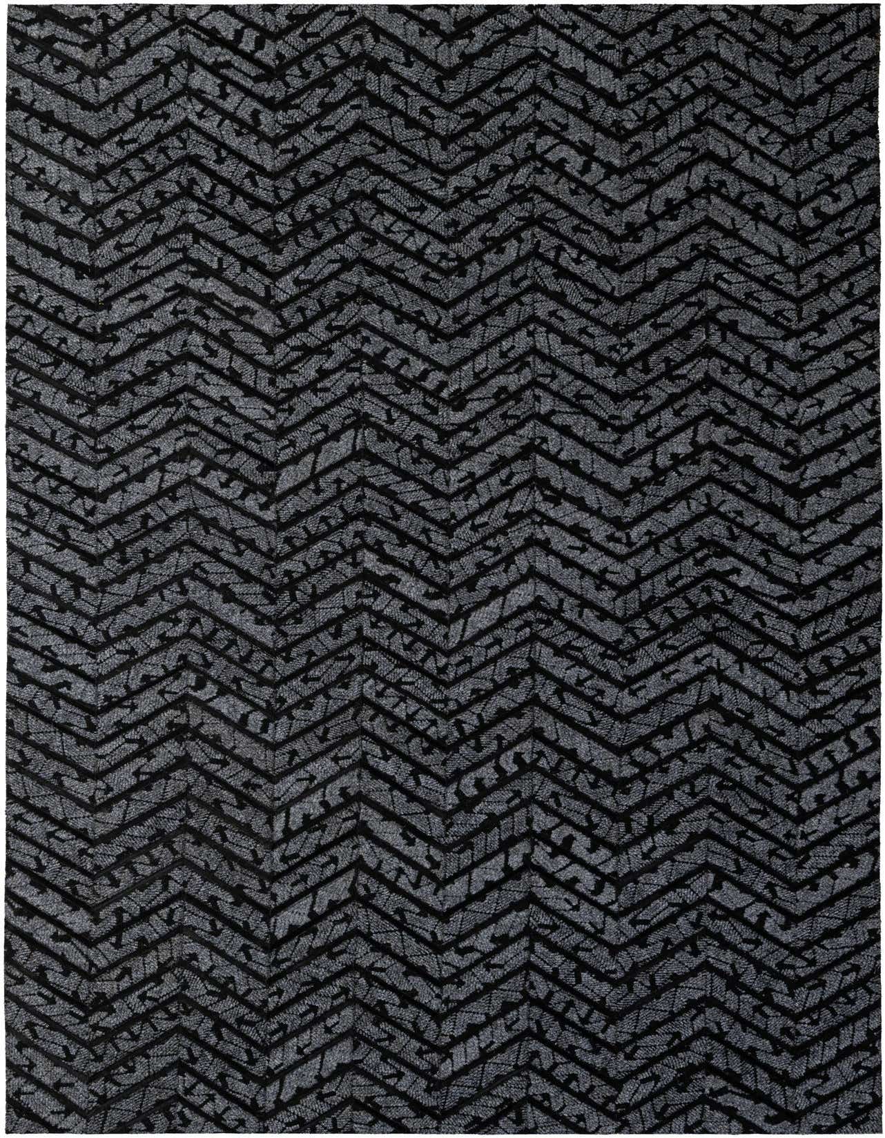 A 5x8 rectangular Cowhide - Patchwork rug featuring a modern chevron stripe pattern in varying shades of black and gray.