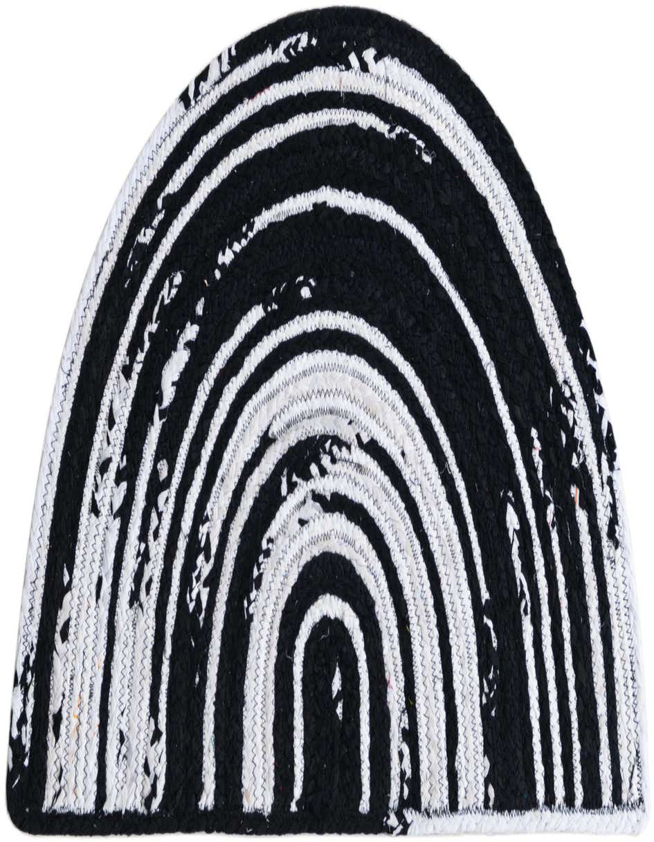 A black and white braided chindi hearth rug with a semi-circular shape and alternating stripes of black and white.