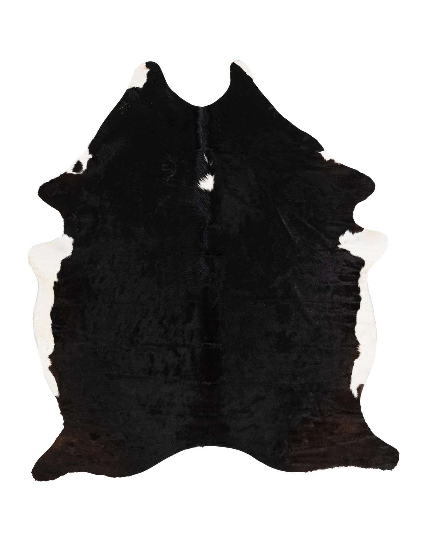 A 6x9 rectangular black and white cowhide rug with natural, irregular edges, featuring a predominantly black center with white patches along the perimeter.