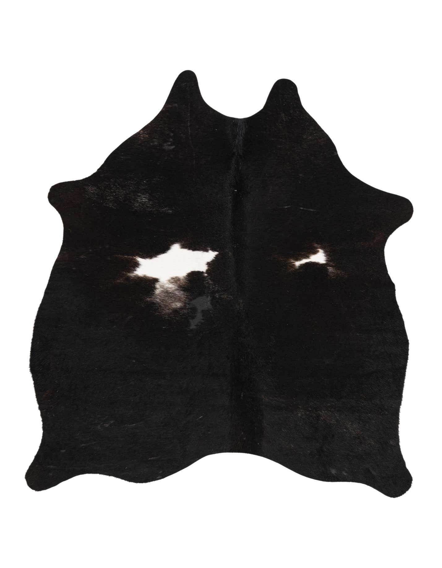 A 4x6 black and white cowhide rug with an irregular shape, featuring natural white markings on a predominantly black background.