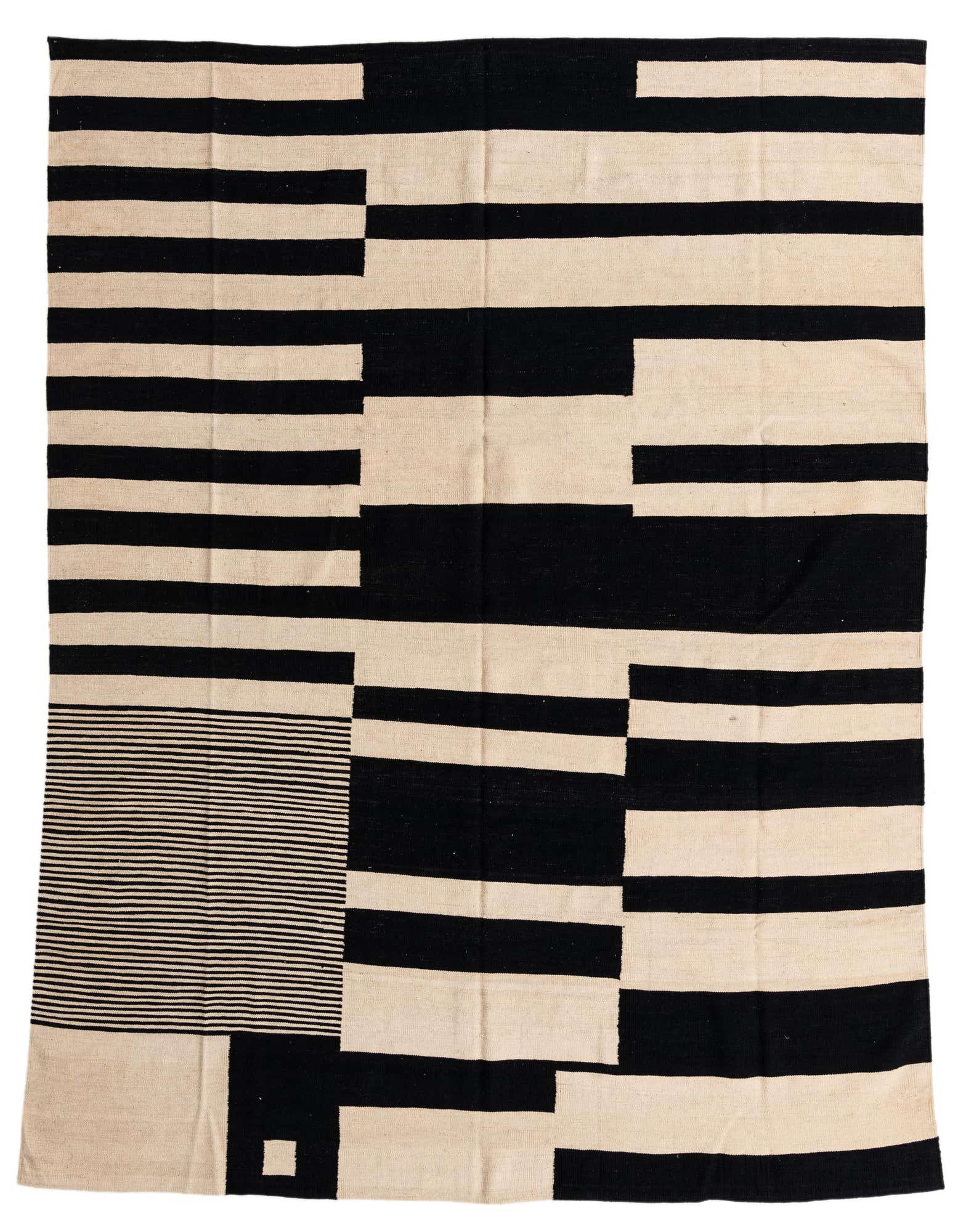 An 8x10 rectangular flatweave rug featuring a bold modern tribal pattern of black and ivory stripes and geometric blocks.