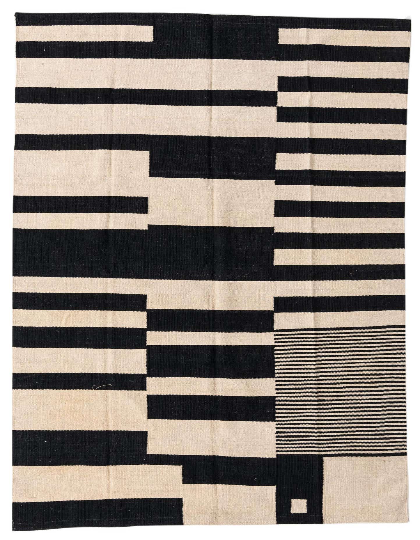 A 5x8 rectangular black and white flatweave wool rug with a modern tribal stripe pattern, perfect for a living room.