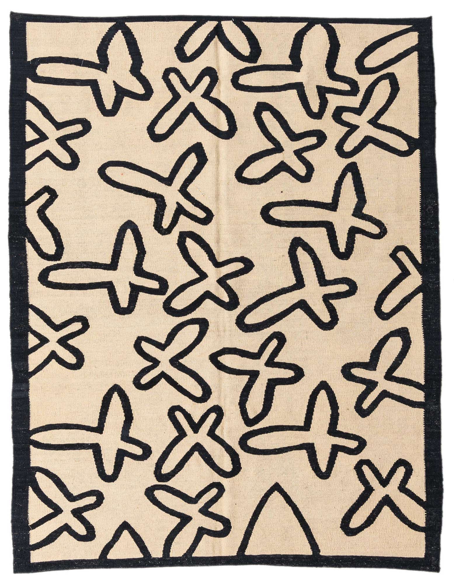 A 5x8 rectangular black and ivory flatweave rug with abstract, tribal-inspired shapes and a black border.