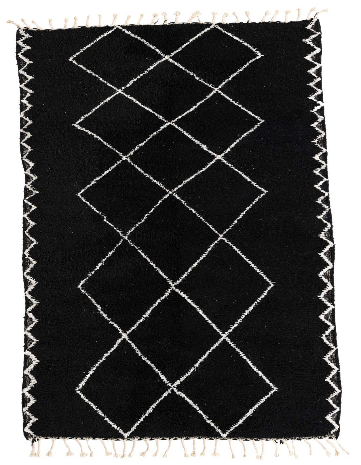 A 5x8 rectangular black shag rug with a white tribal diamond pattern and fringed ends, suitable for a living room.