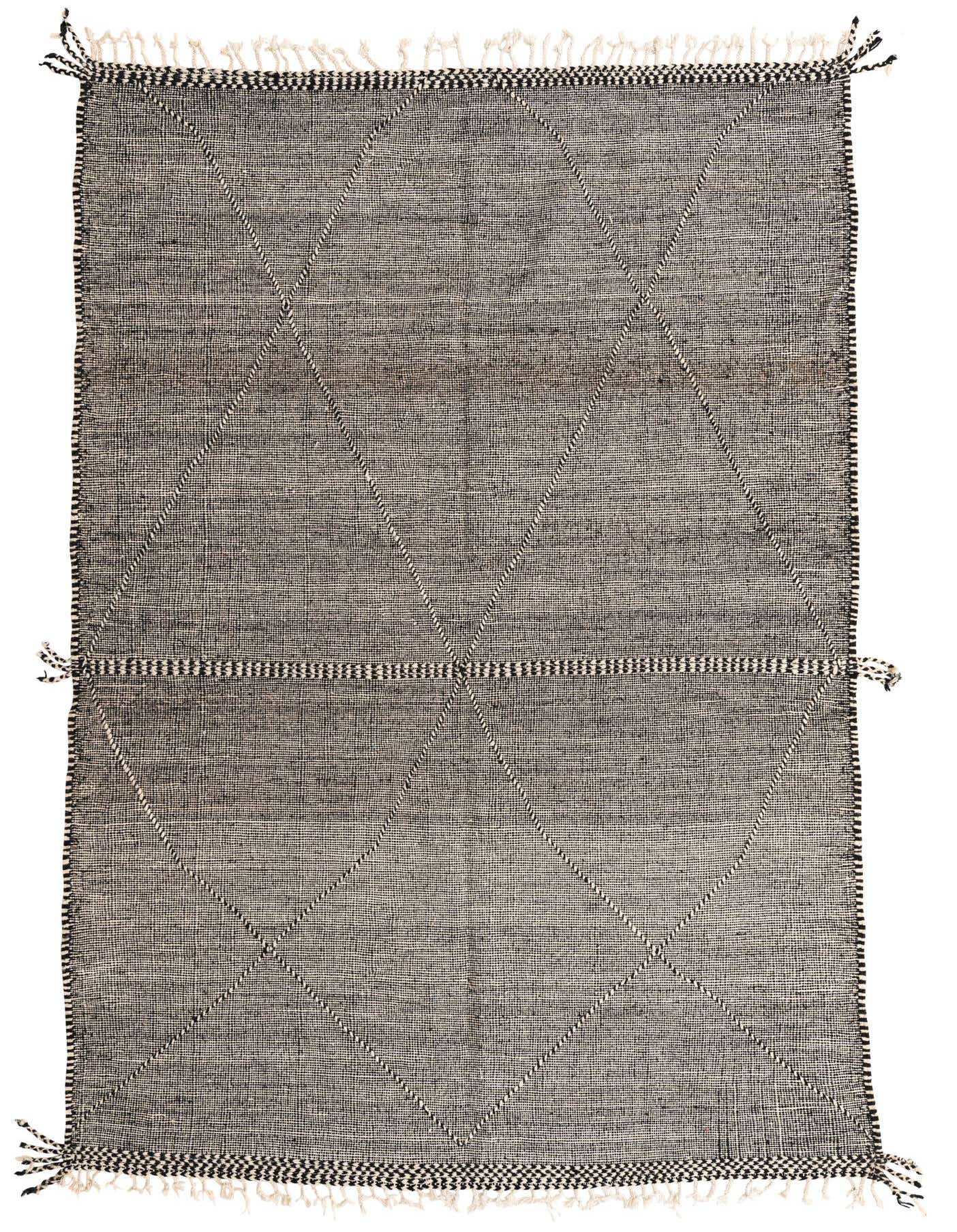 A 7x10 rectangular black and white tribal wool shag rug with a diamond pattern and fringe.