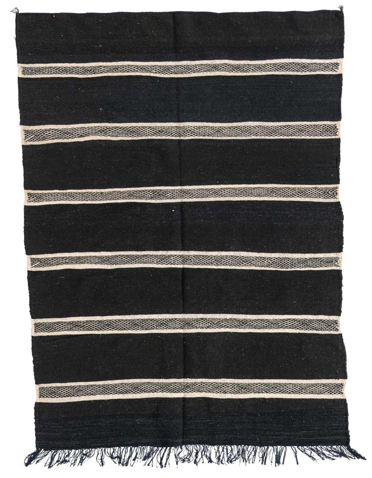 A 5x8 rectangular black wool shag rug with horizontal ivory and black patterned tribal stripes and fringe.