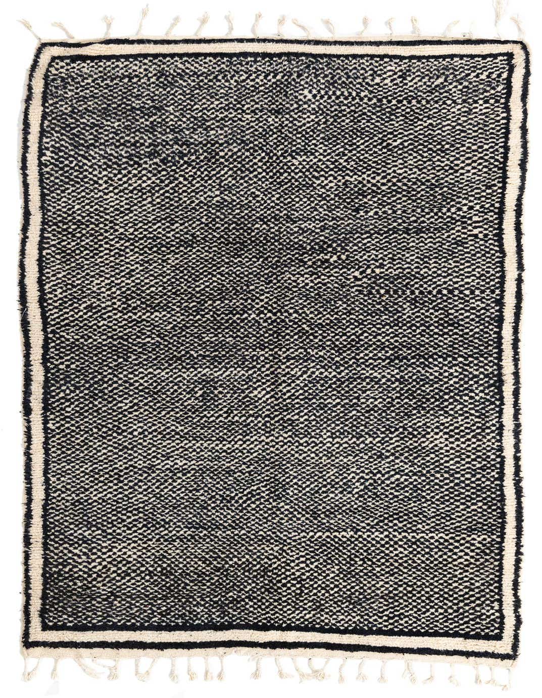 A 5x8 rectangular black and white tribal shag rug with a cream border and fringe, suitable for a living room.