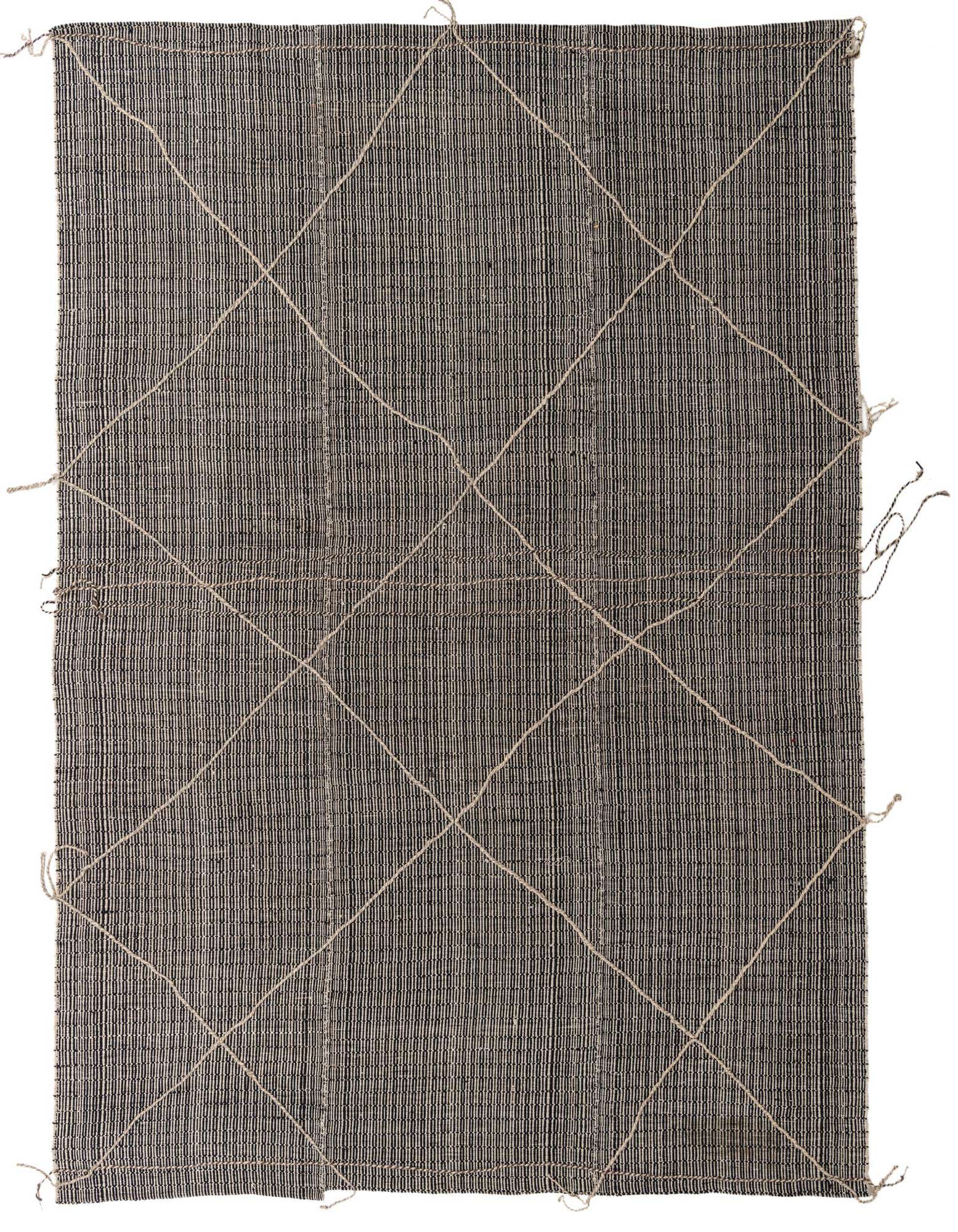 A 9x12 rectangular black and white tribal shag rug with a diamond pattern created by natural fiber strands.