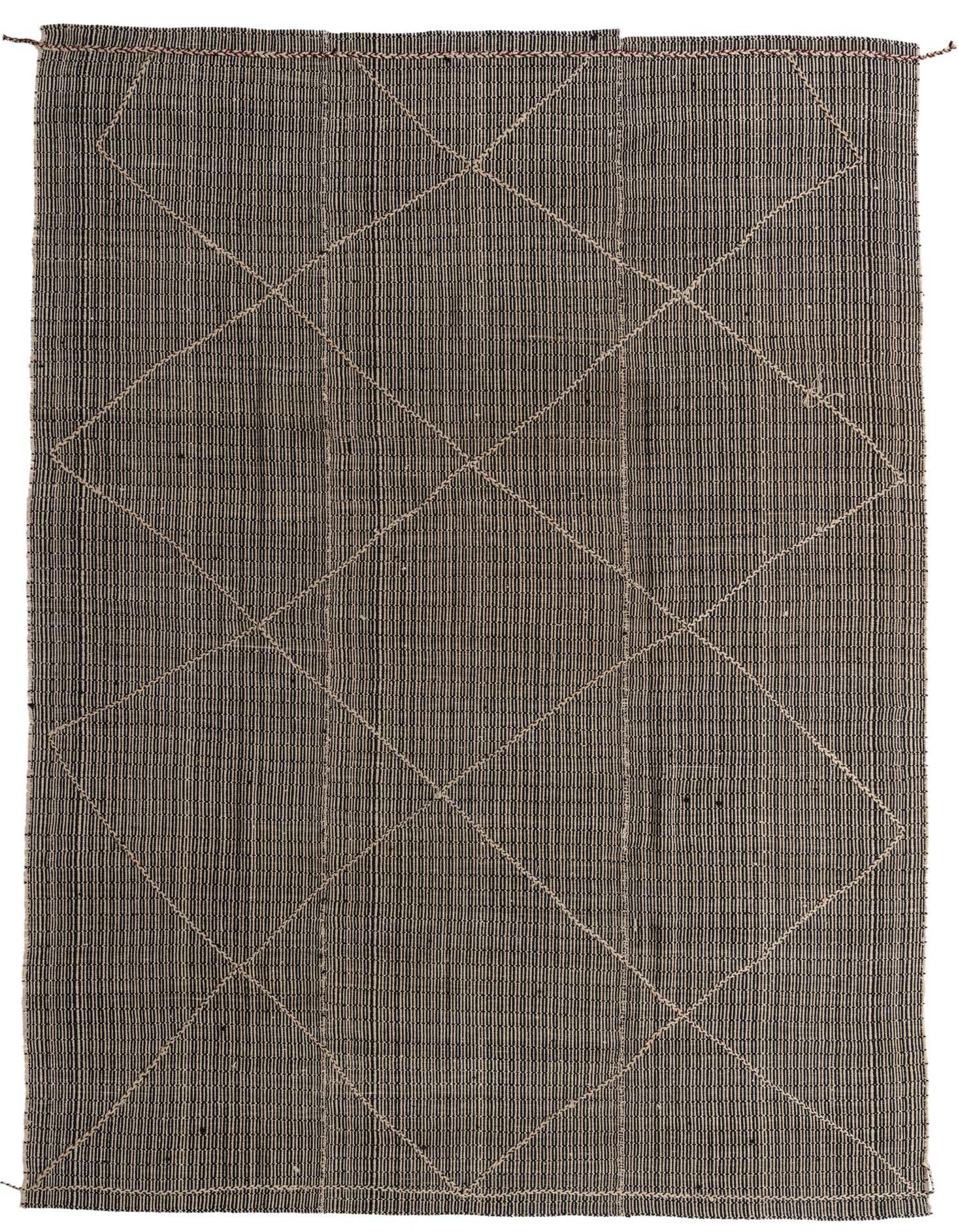 A 9x12 rectangular black wool shag rug with an ivory tribal geometric pattern, suitable for a living room.