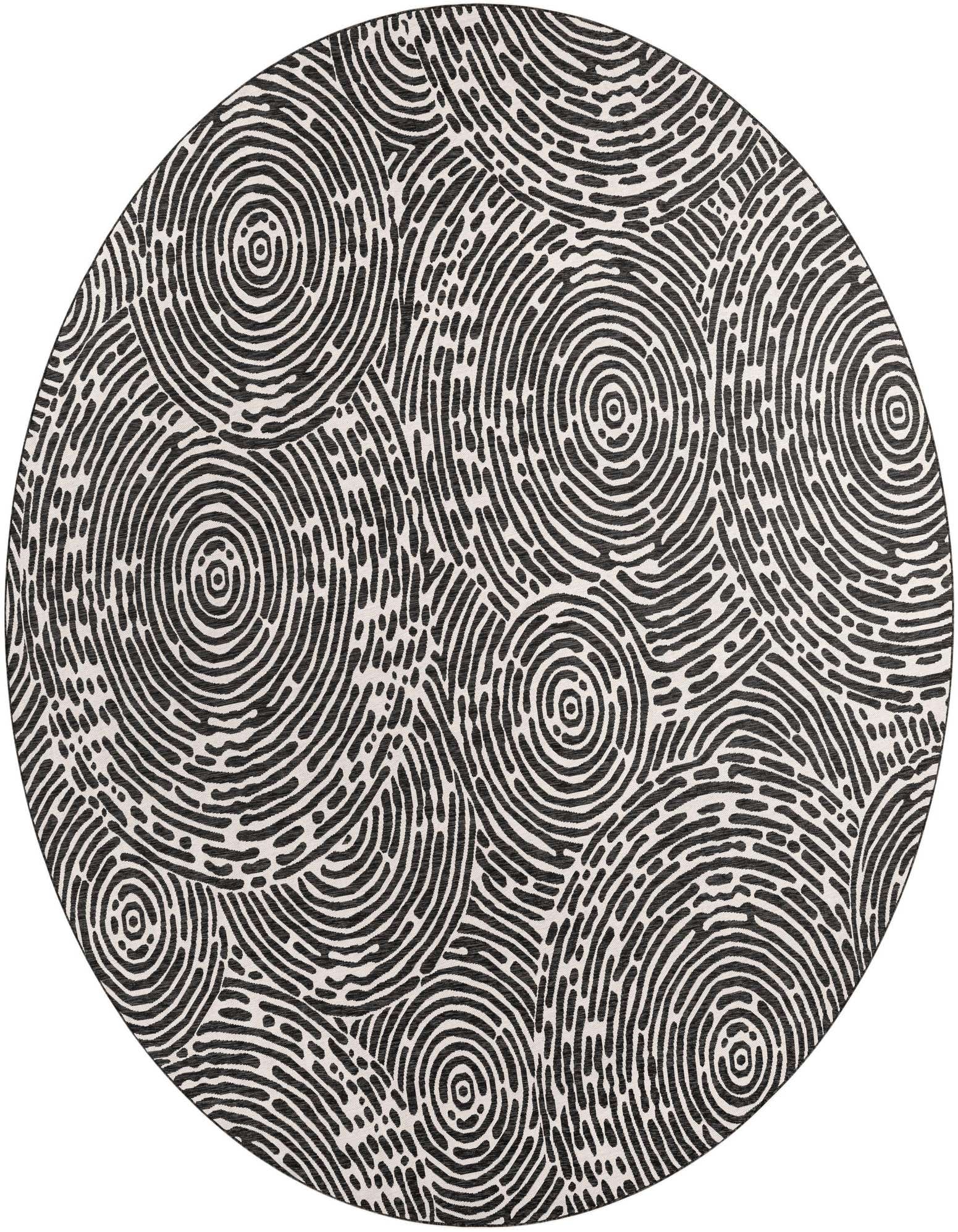 A large round black and white modern abstract rug featuring a pattern of concentric circles and organic lines.